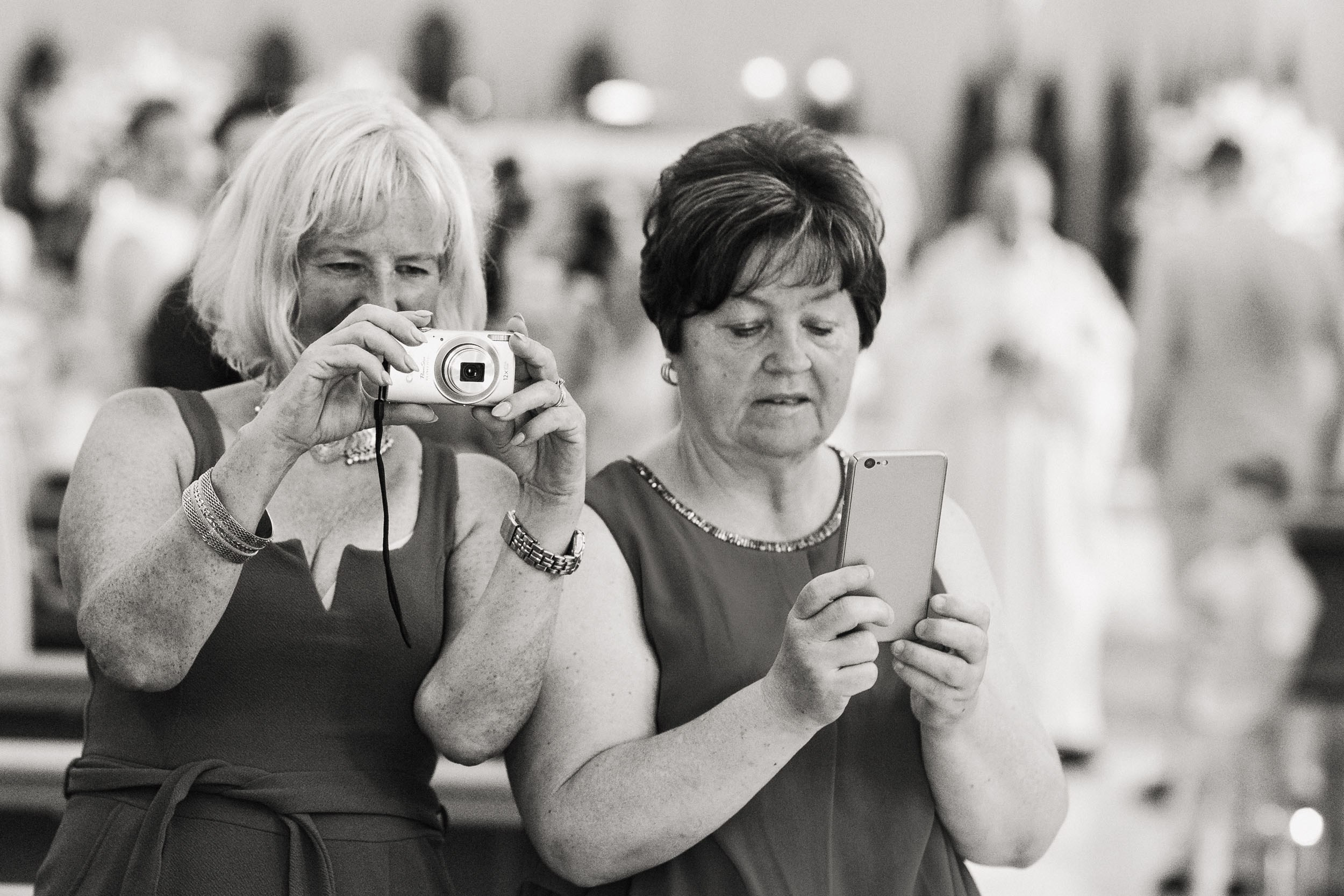 Old ladies are preparing their phones to photograph the bride and groom