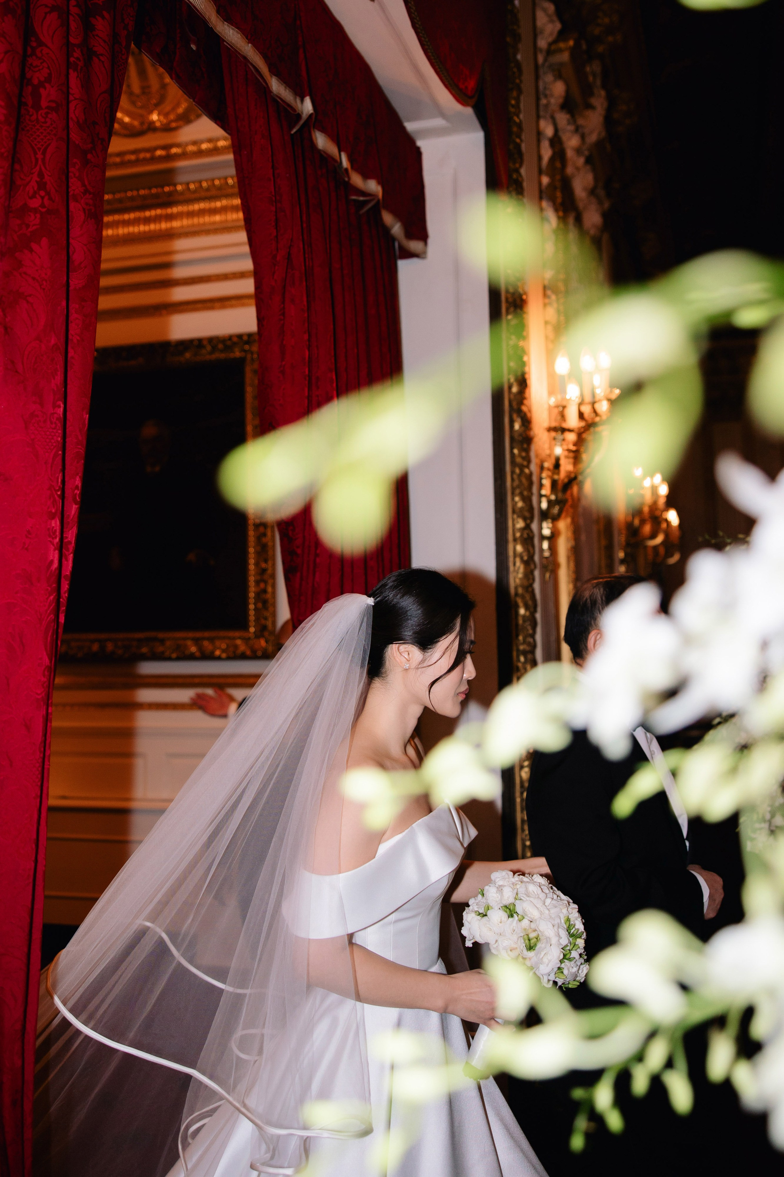 a bride and groom are standing in front of a mirror