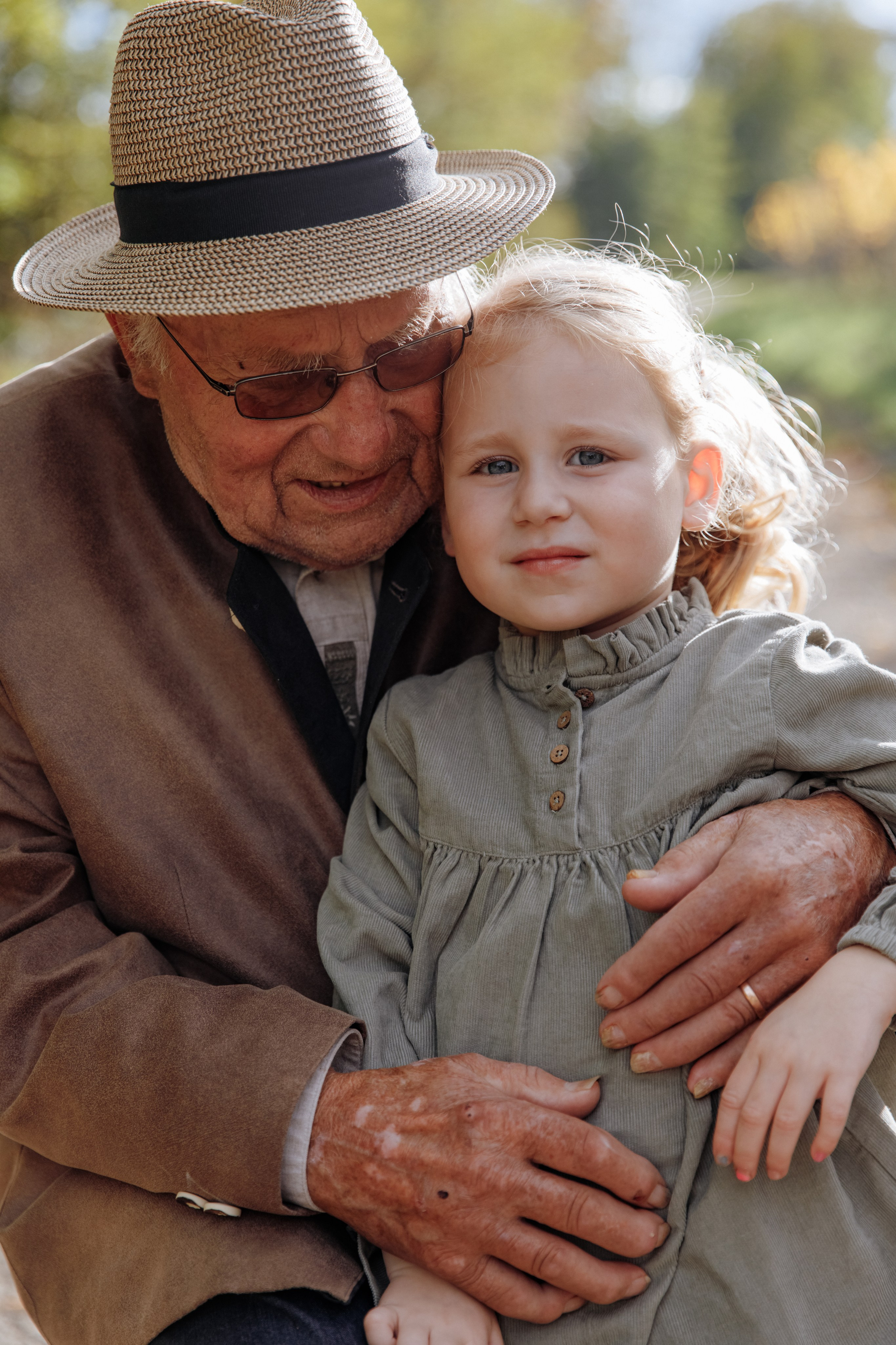 Der Urgroßvater umarmt liebevoll seine Urenkelin – ein berührender Generationenmoment.