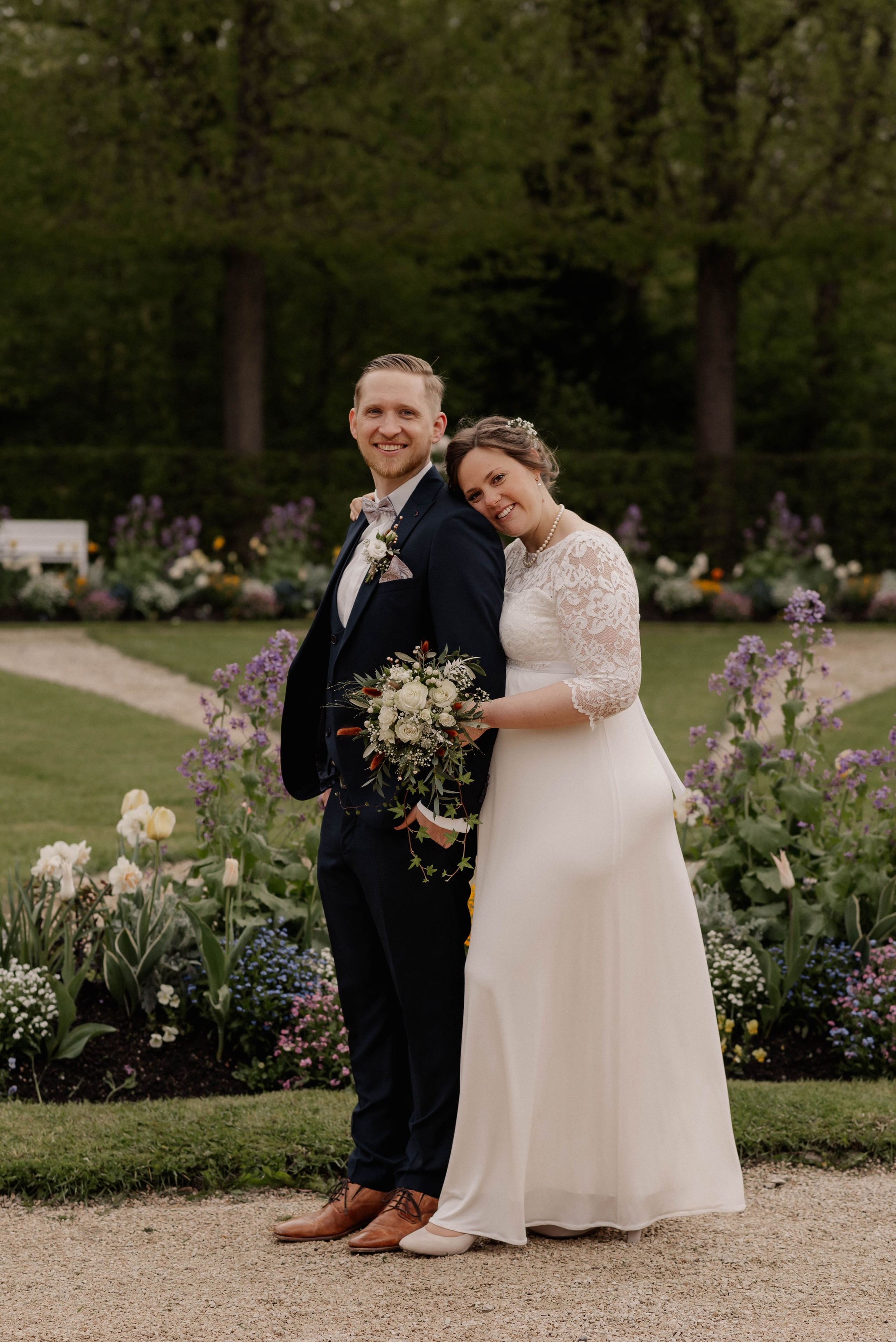 Die glückliche Braut umarmt den Bräutigam bei der Hochzeit in Orangerie Ansbach