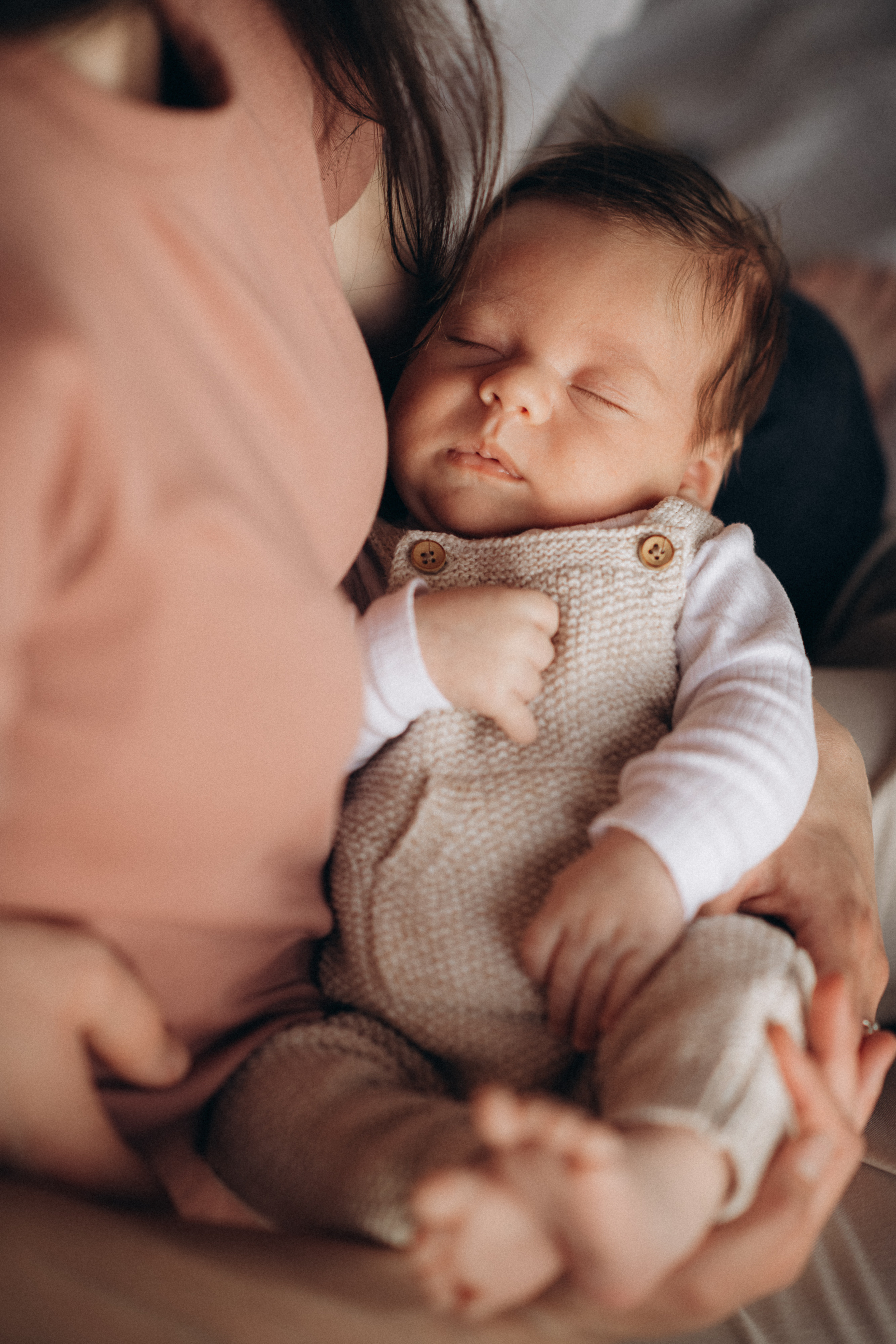 newborn baby sleeping in the mother's arms