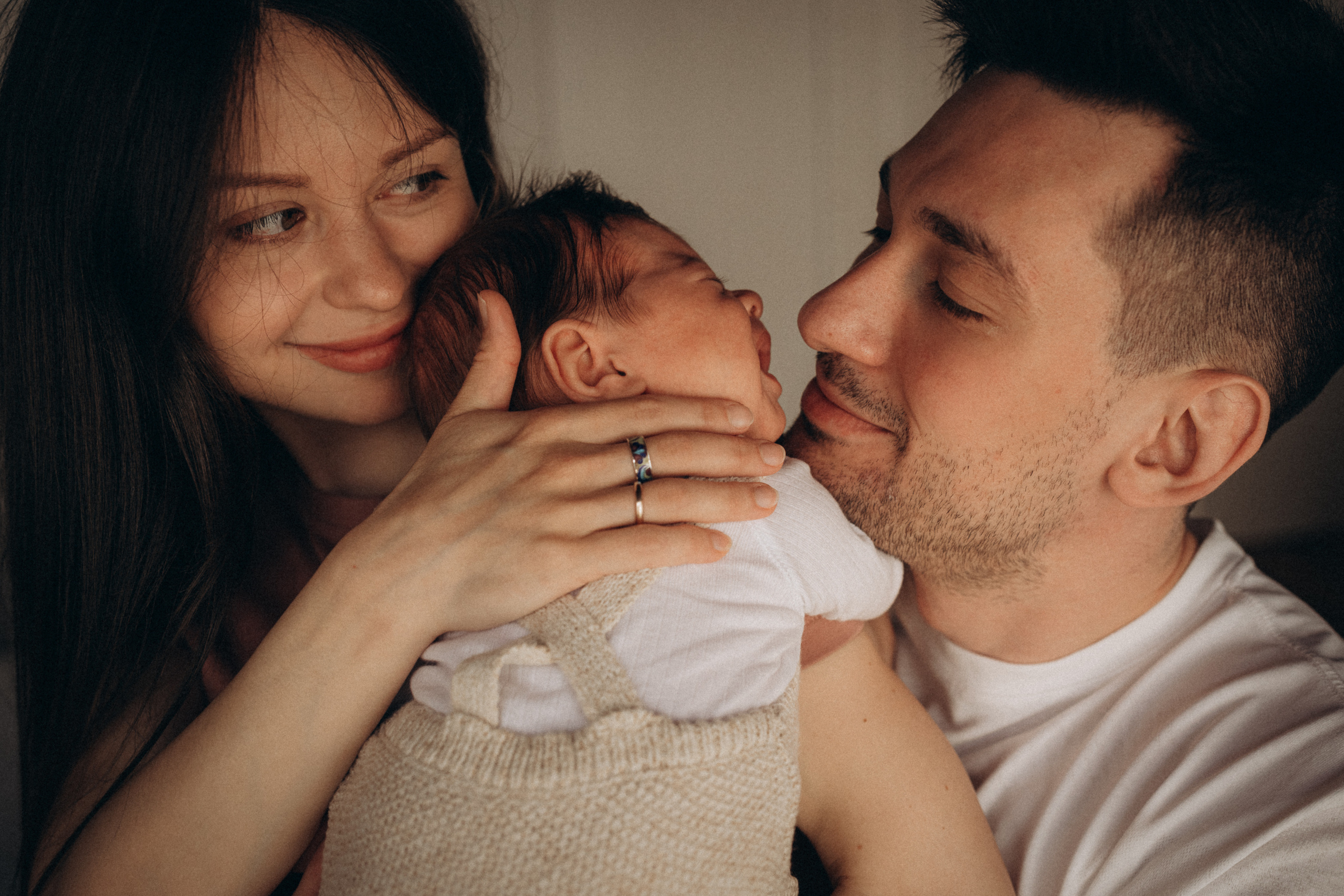 portrait of young parents hold their newborn baby boy