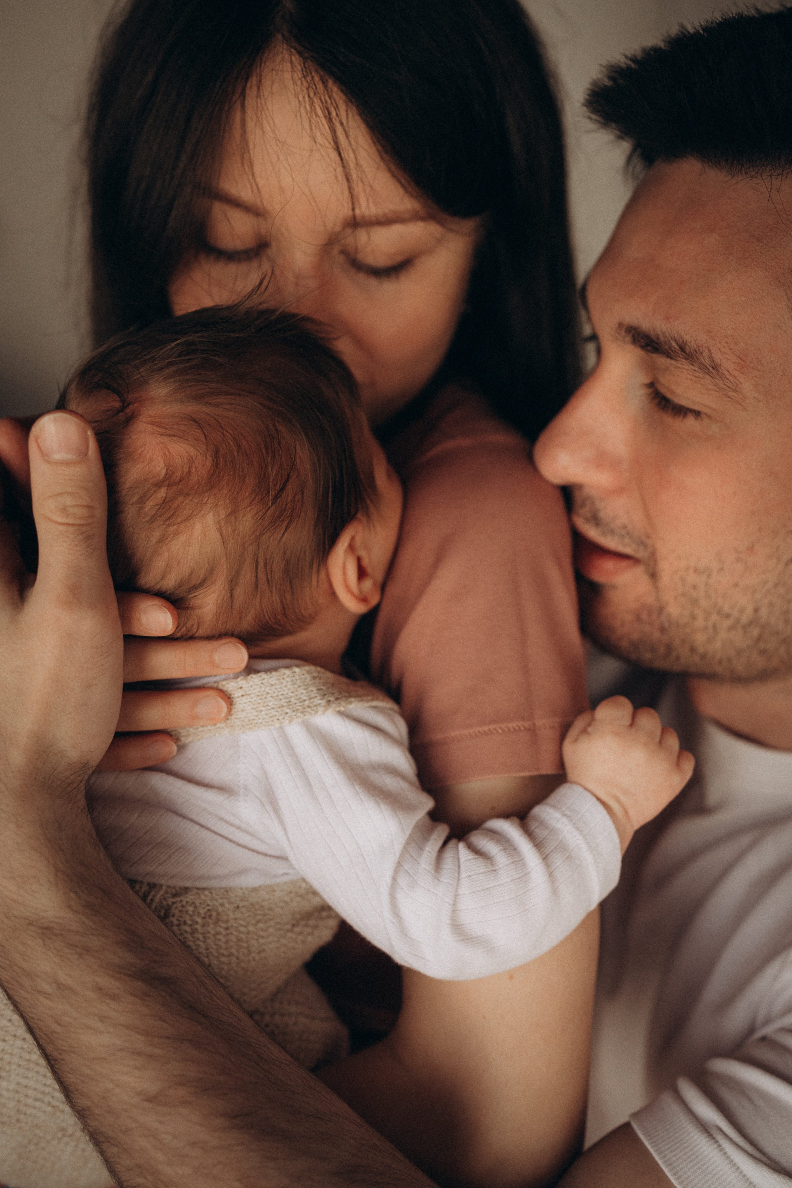 candid portrait of parents with newborn baby