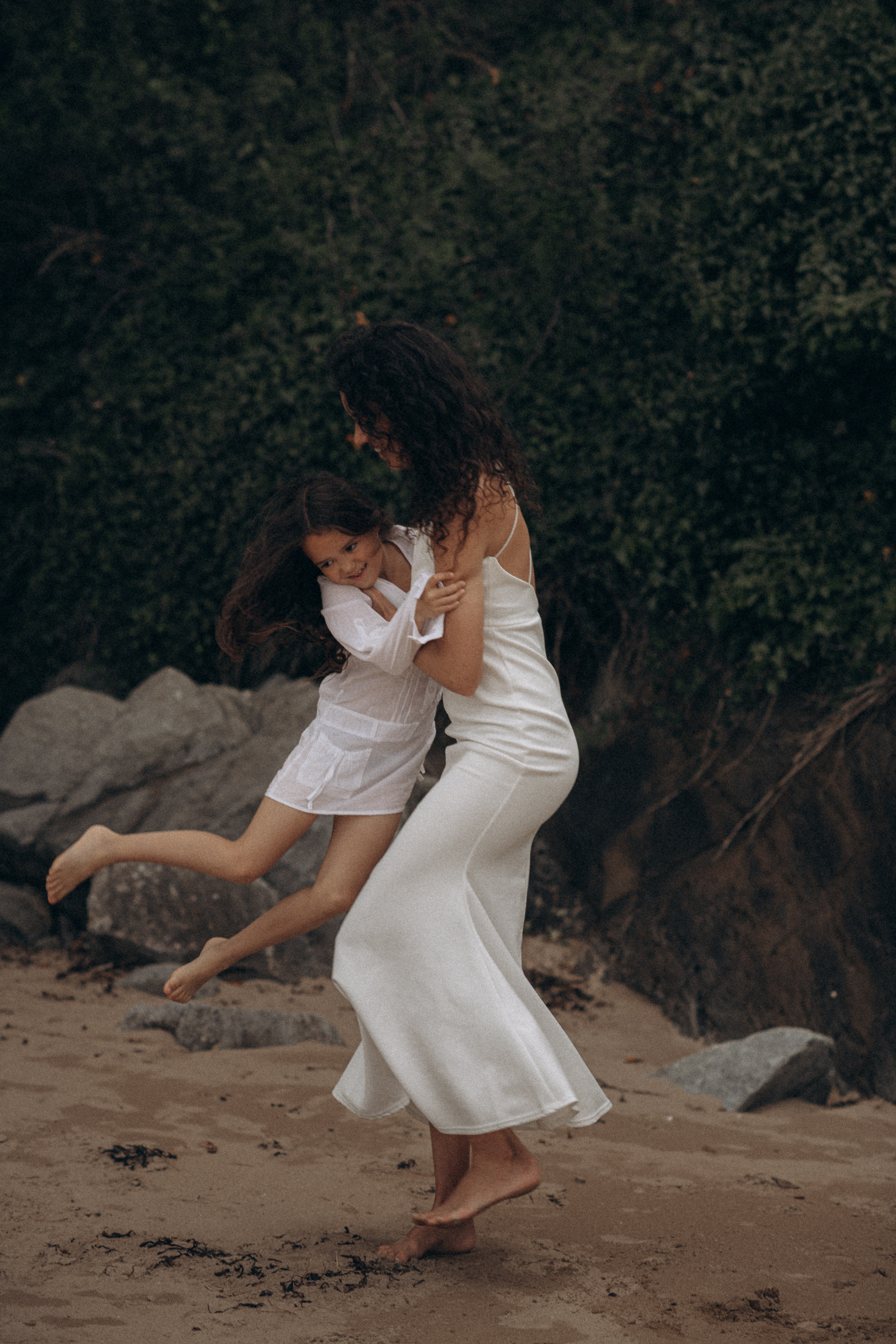 mum and daughter play on the beach