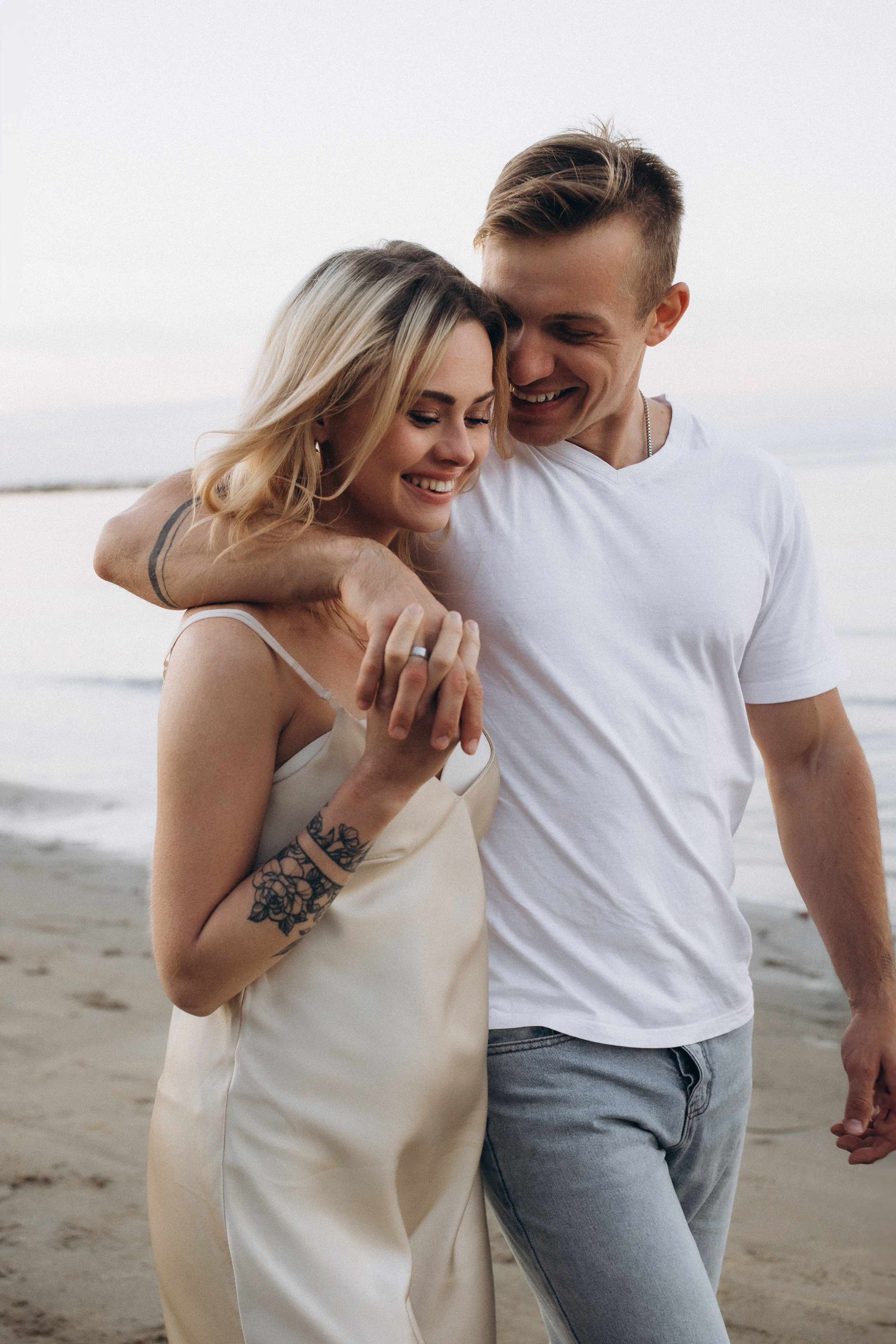 coppia che cammina abbracciata sulla spiaggia durante una sessione fotografica love story a Rimini