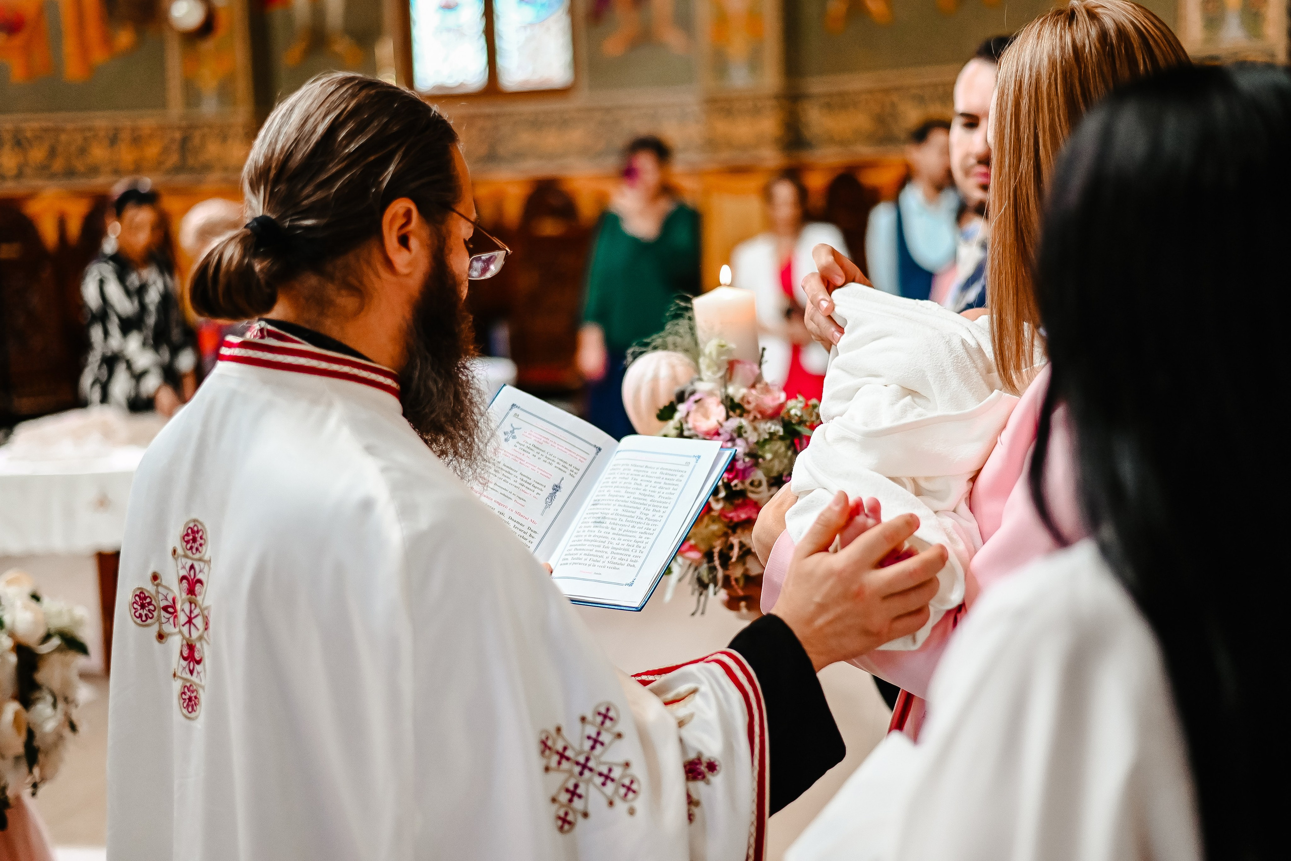 Preot binecuvântând copilul în timpul botezului – fotografie Ana Maria Drăgan