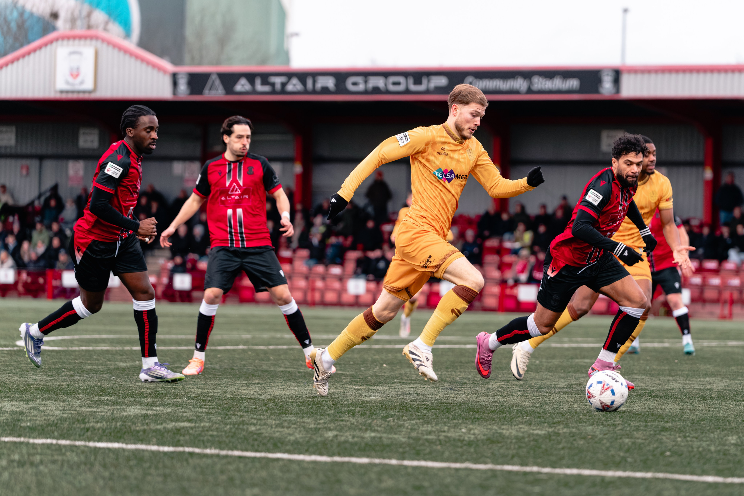 Sutton United’s Lewis Simper presses as Tamworth’s Luke Fairlamb carries the ball in midfield.