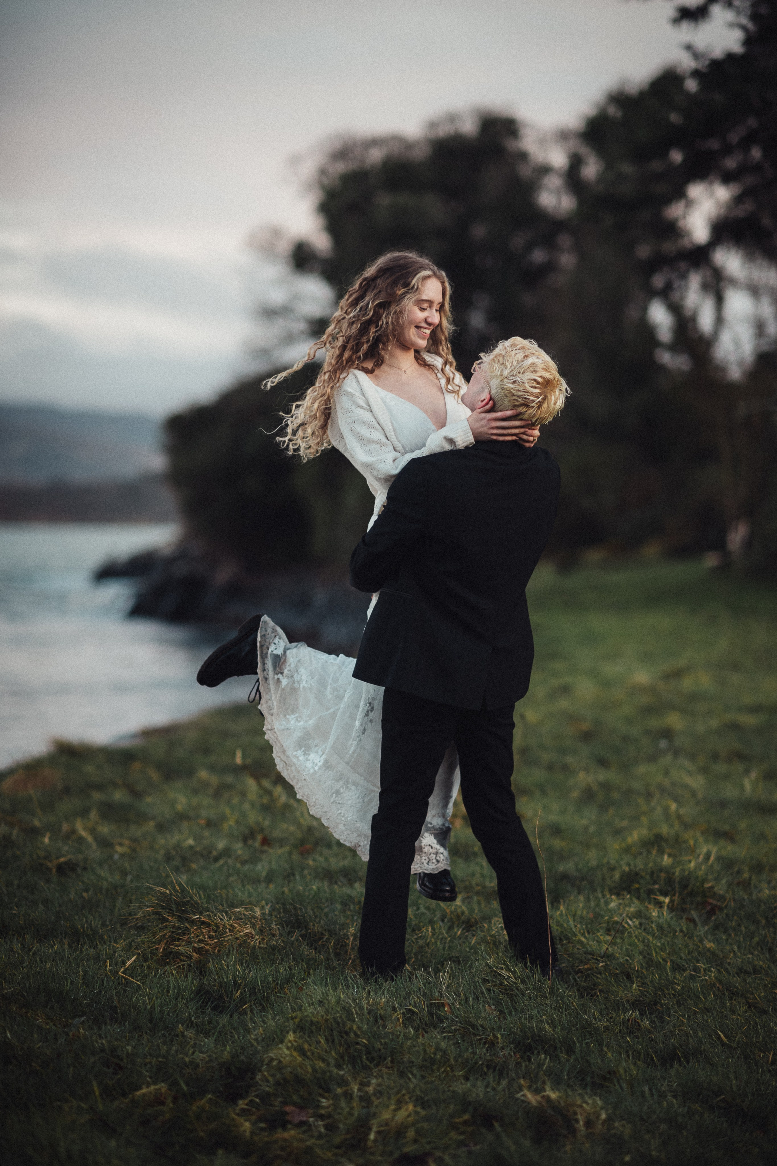 man and woman by the lake engagement