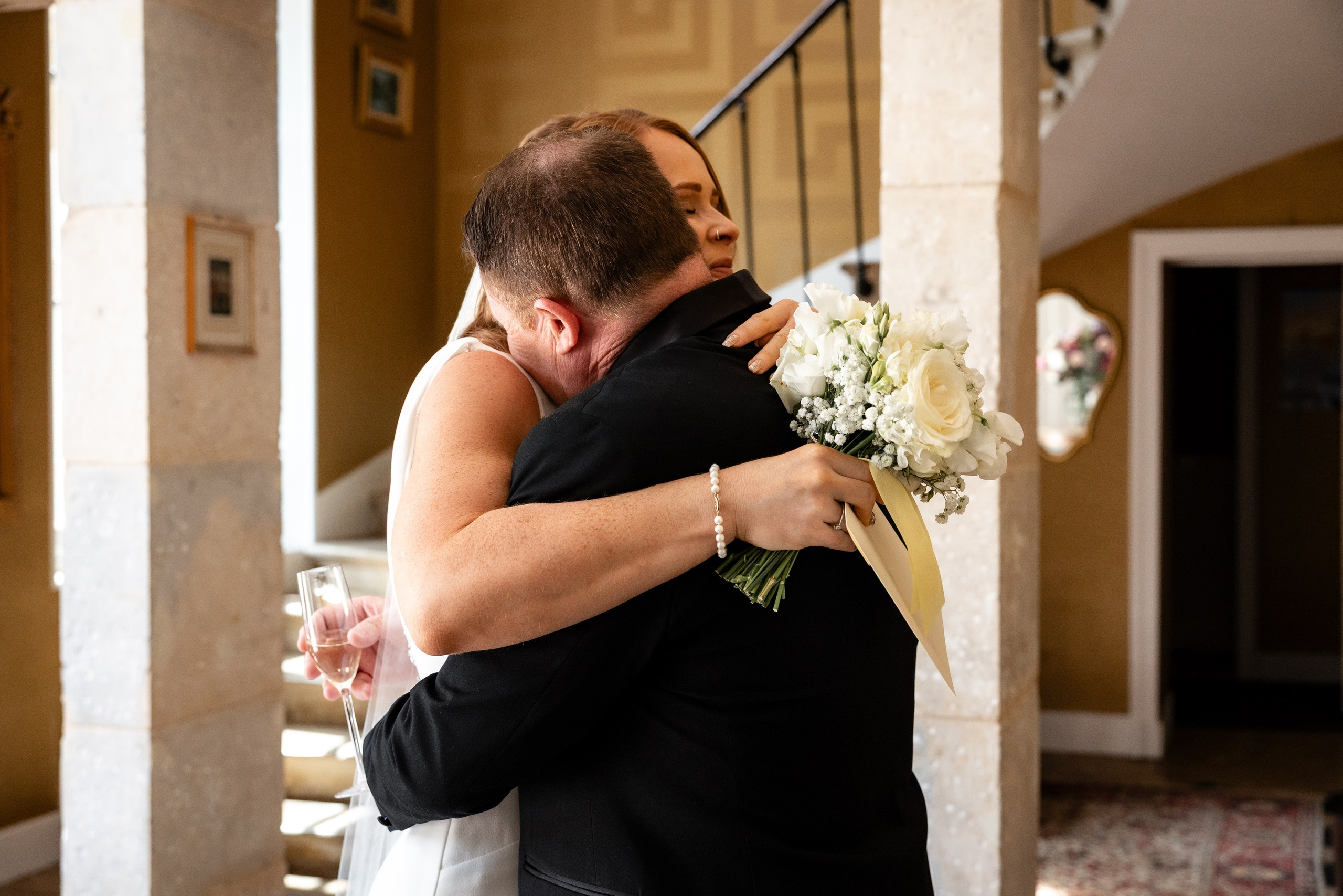 Bride and her father embracing in the doorway before the ceremony