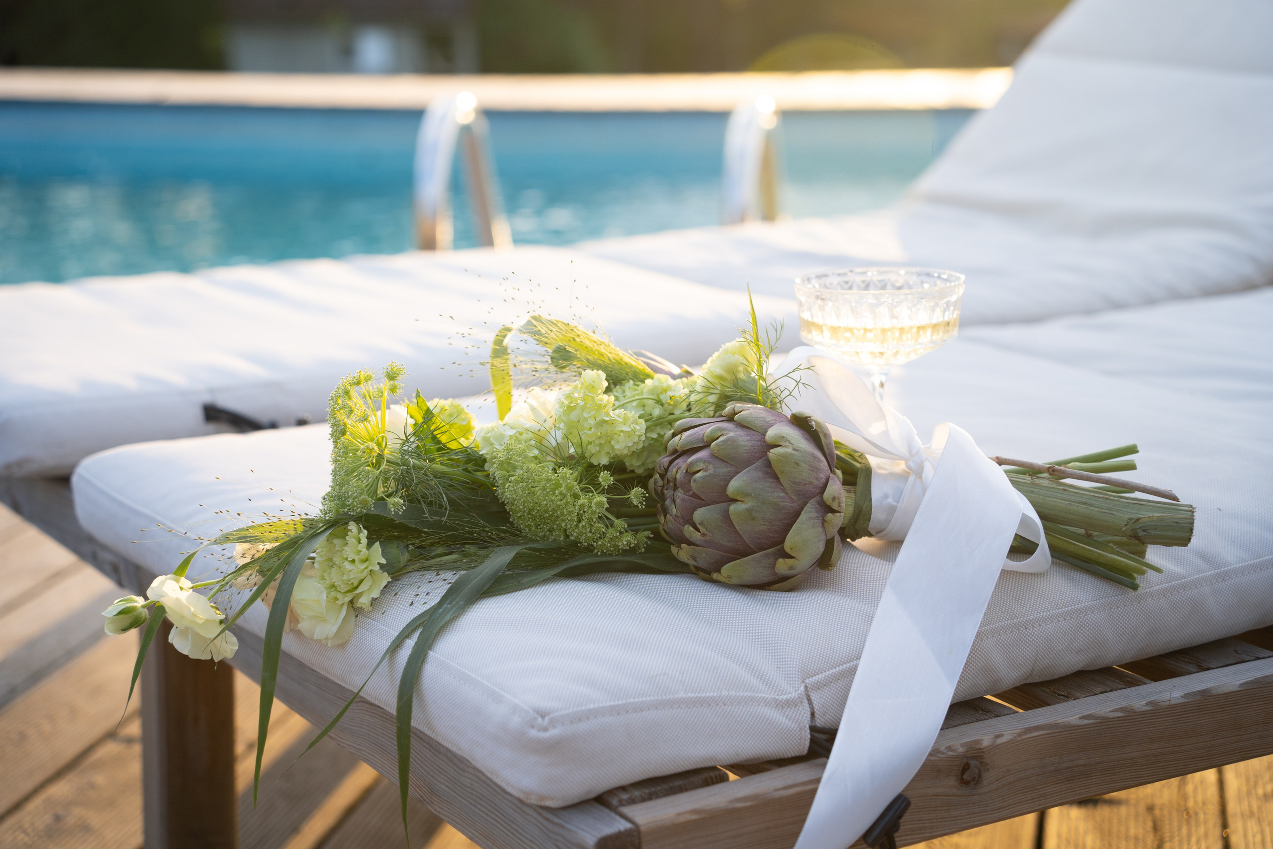Detail svatební dekorace s květinami u bazénu. Elegantní a jemná atmosféra svatebního dne zachycená ve stylovém aranžmá. 