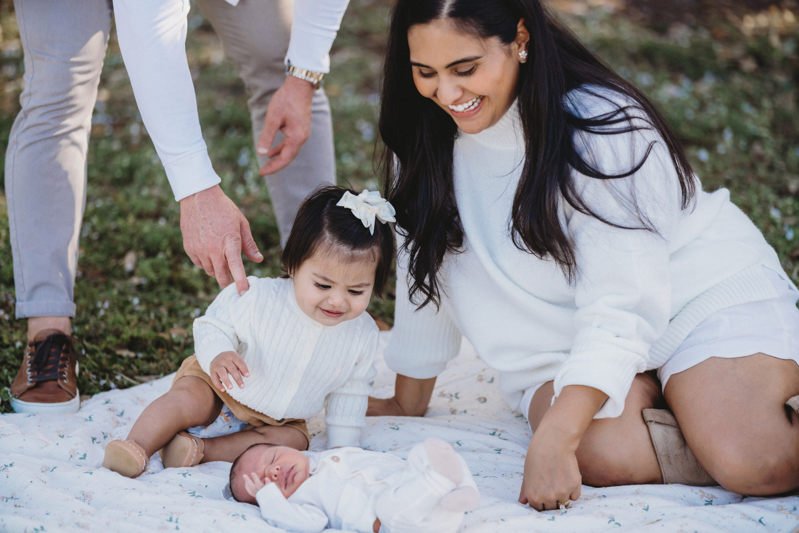 Mother and little girl looking at baby