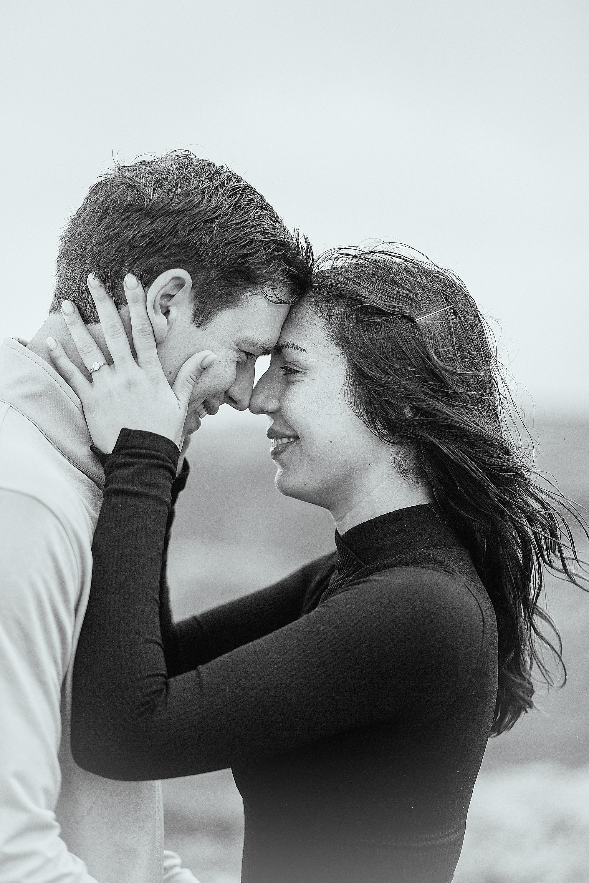 Close-up black and white portrait of a newly engaged couple sharing a tender moment near Doolin.