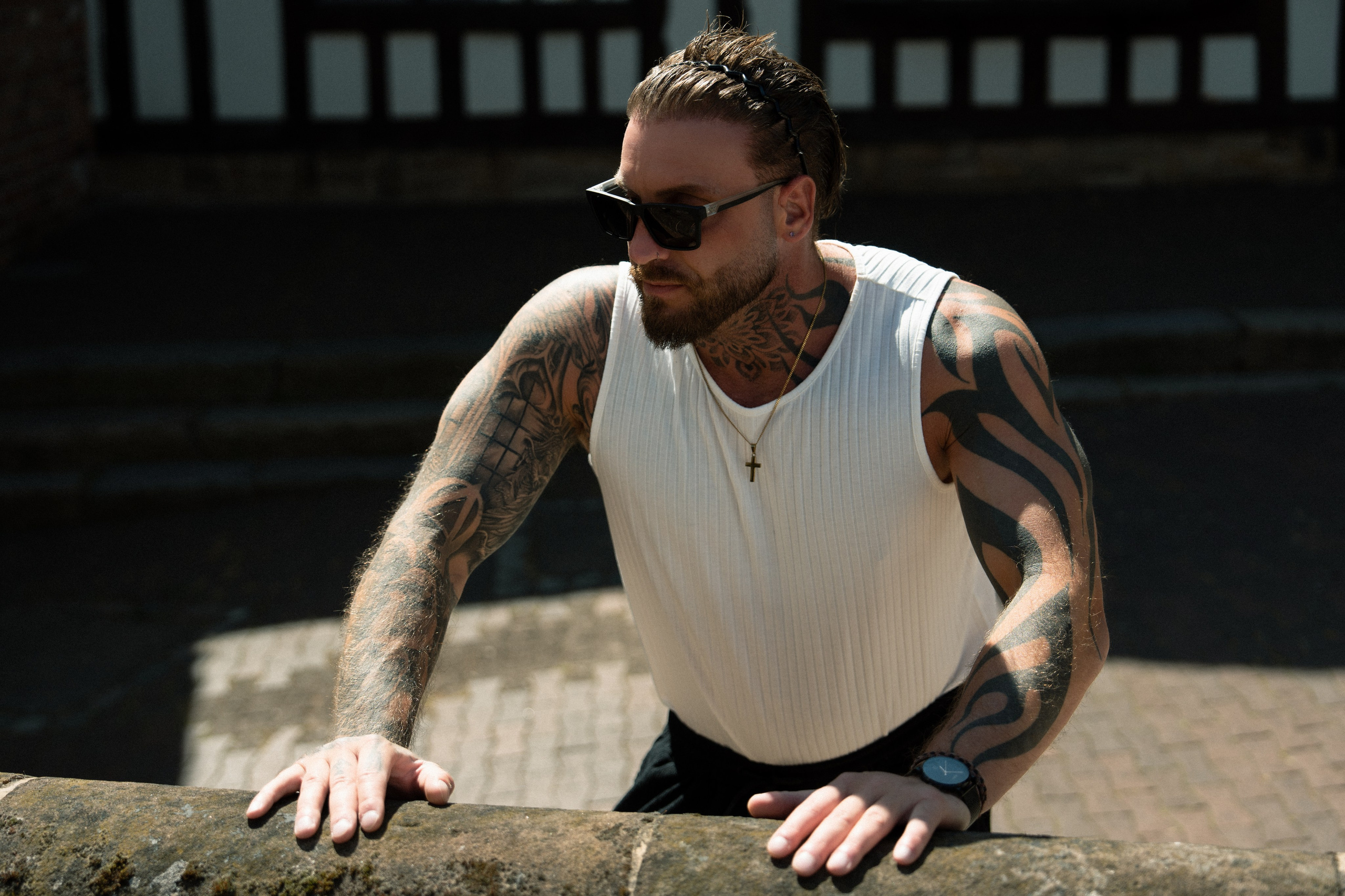 Outdoor portrait of a tattooed man in natural sunlight