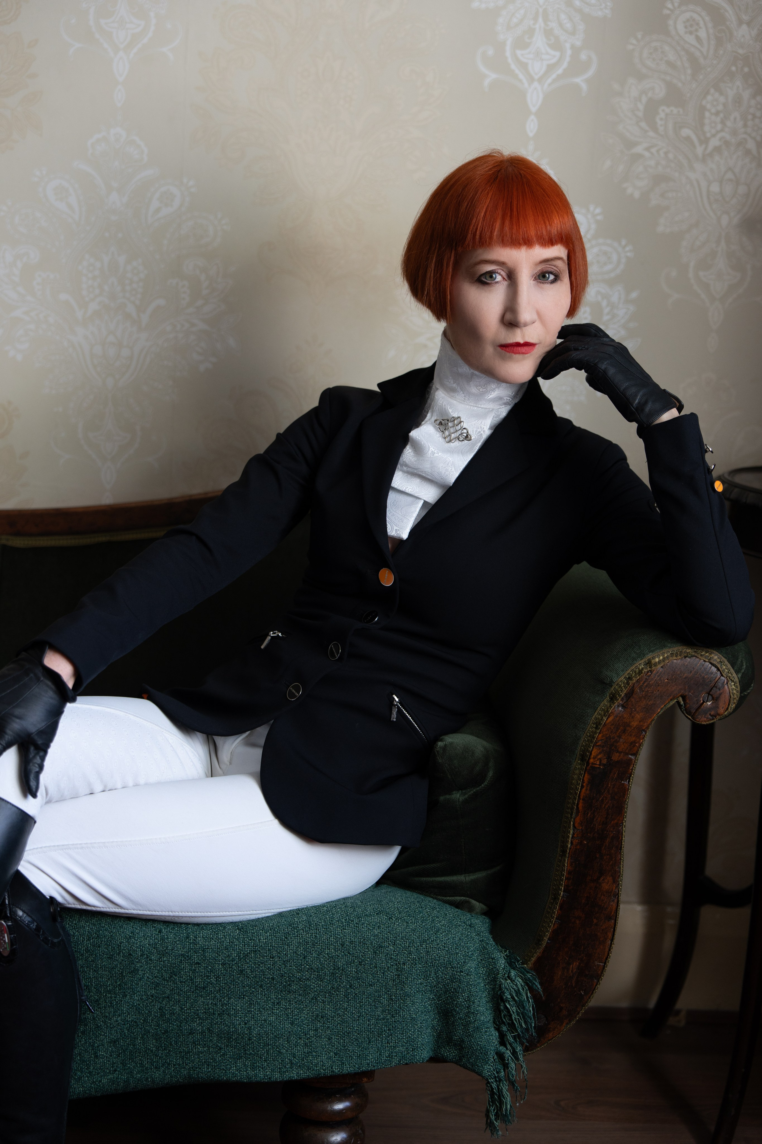 Editorial portrait of a red-haired woman in tailored black and white styling