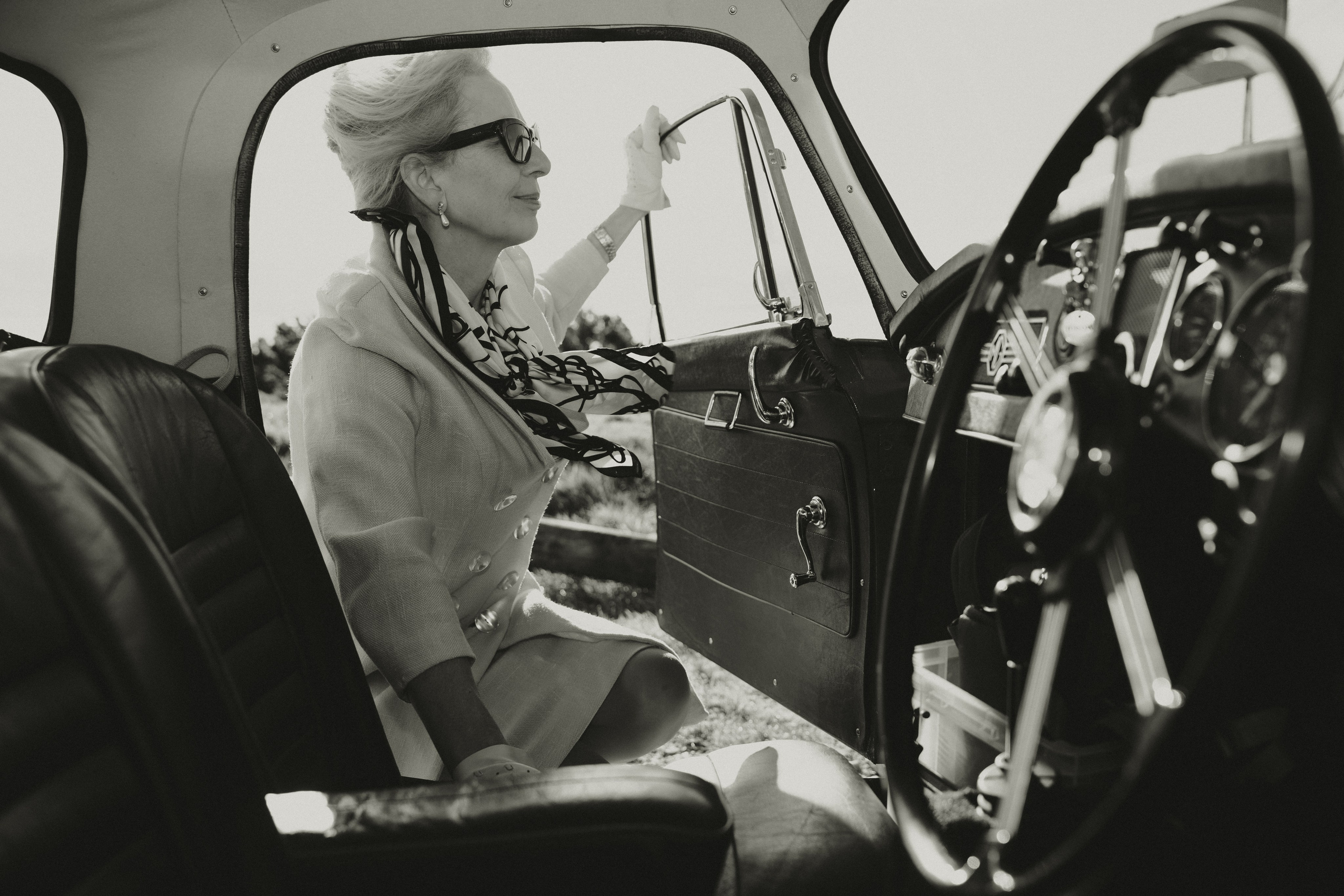 Black and white lifestyle portrait inside a classic car