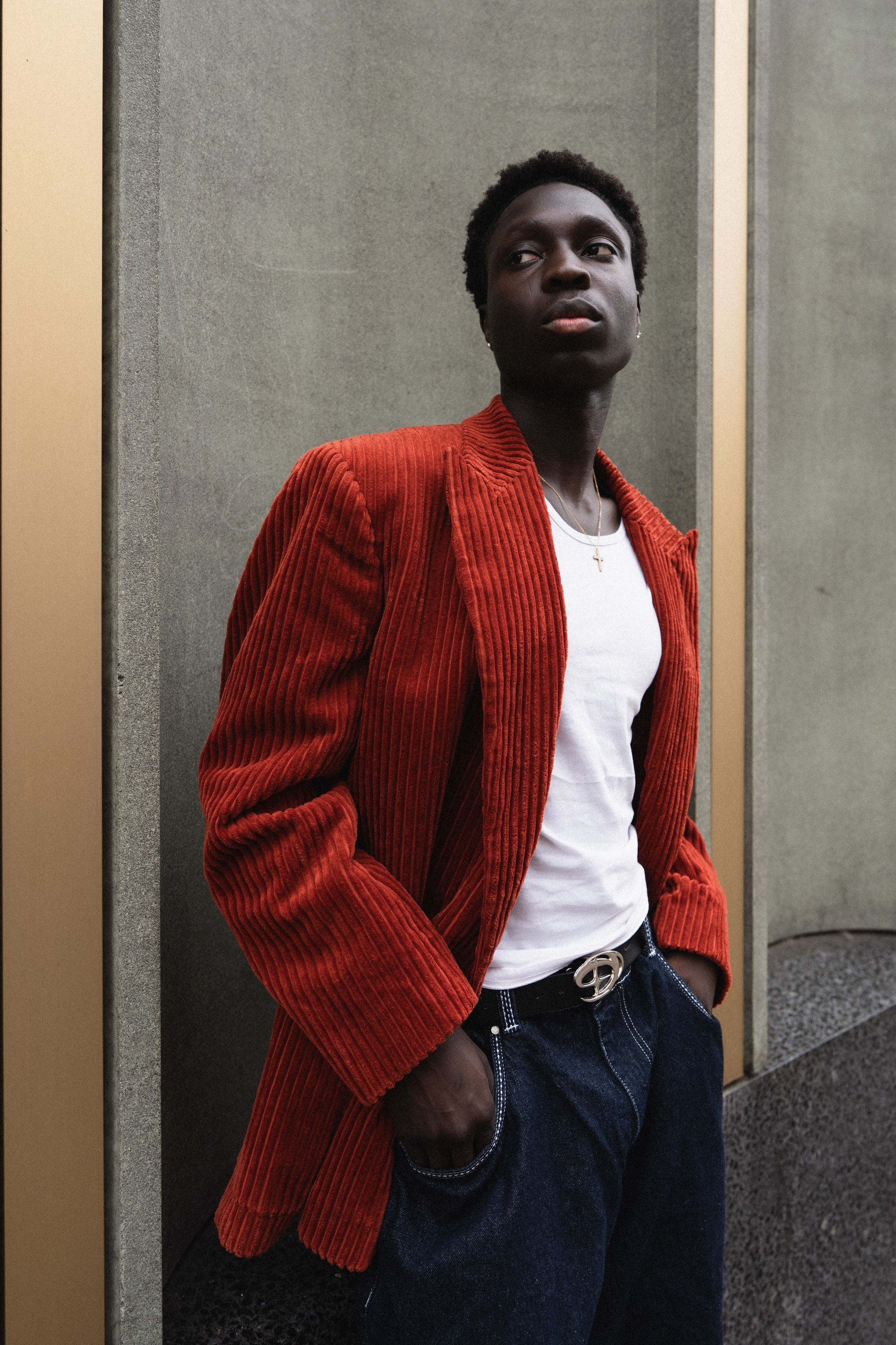 Male model wearing a red jacket in an urban editorial portrait