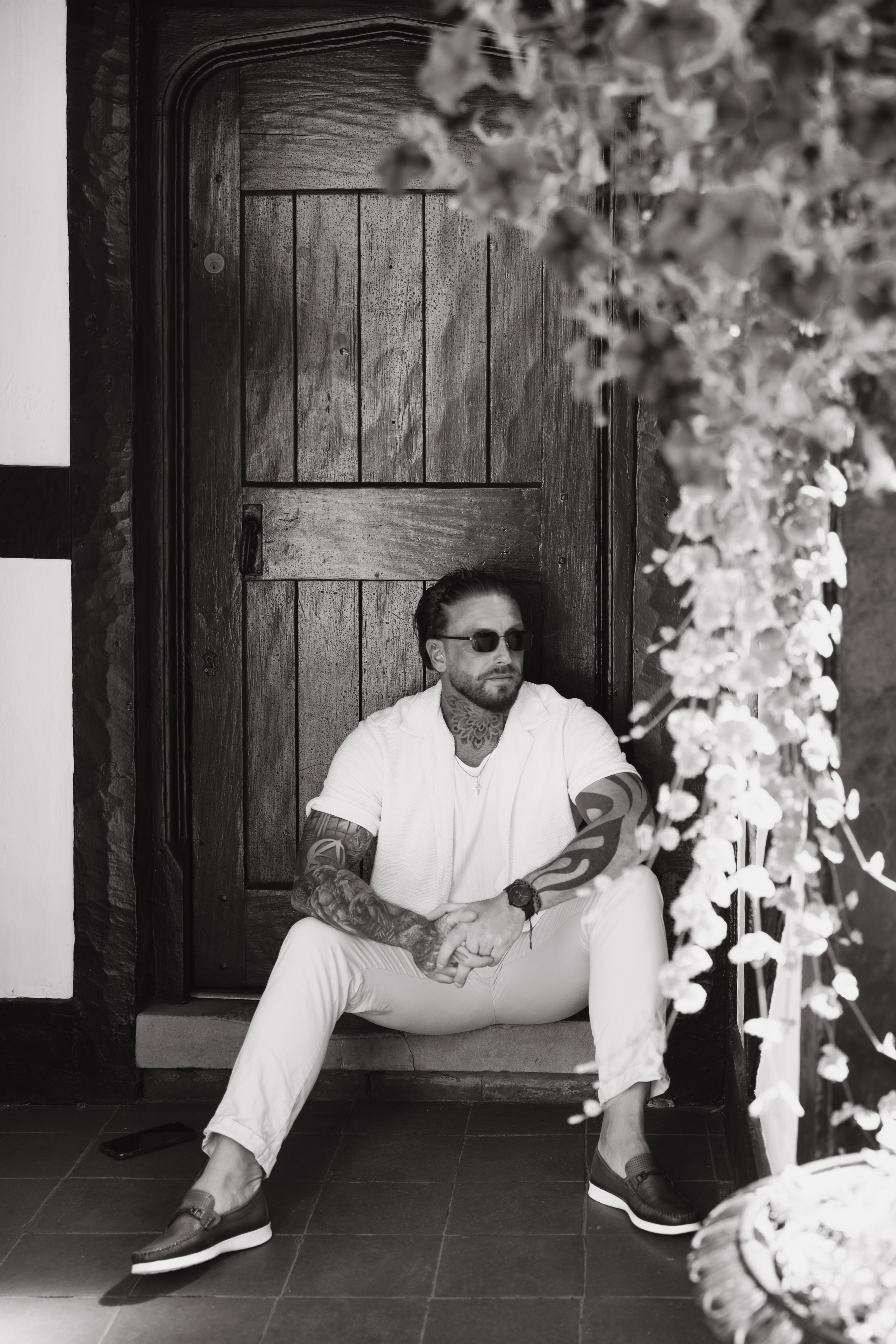 Black and white environmental portrait of a man in a historic setting