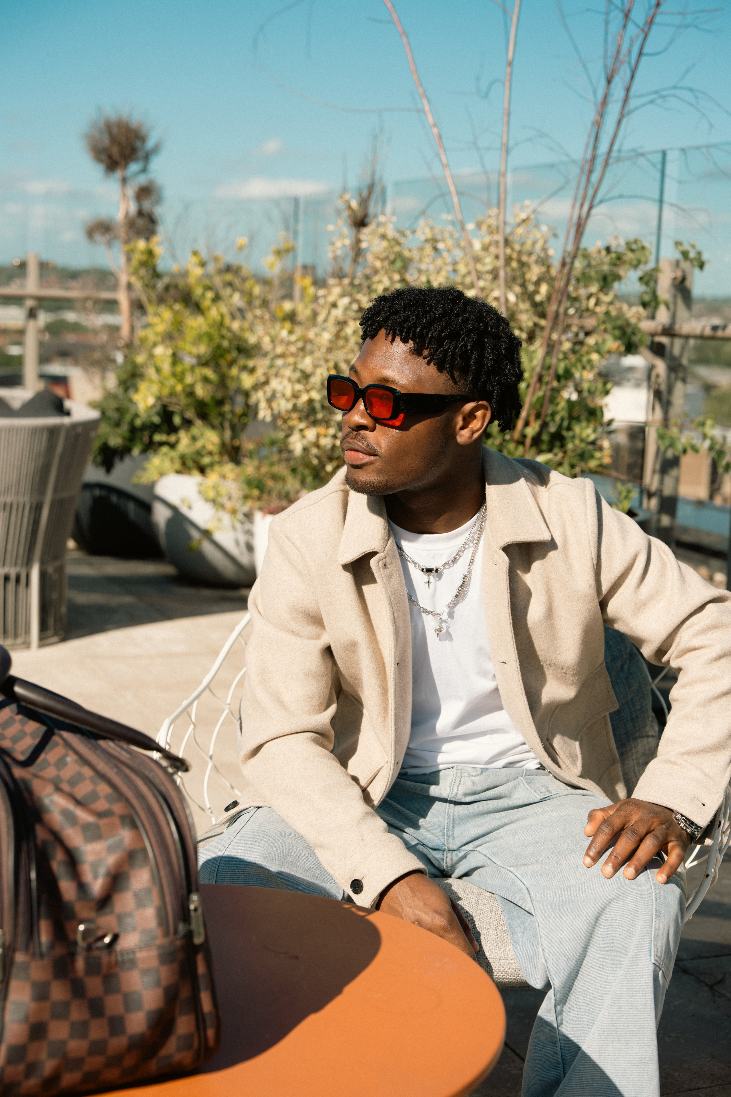 Editorial rooftop portrait of a male model in sunglasses and casual fashion