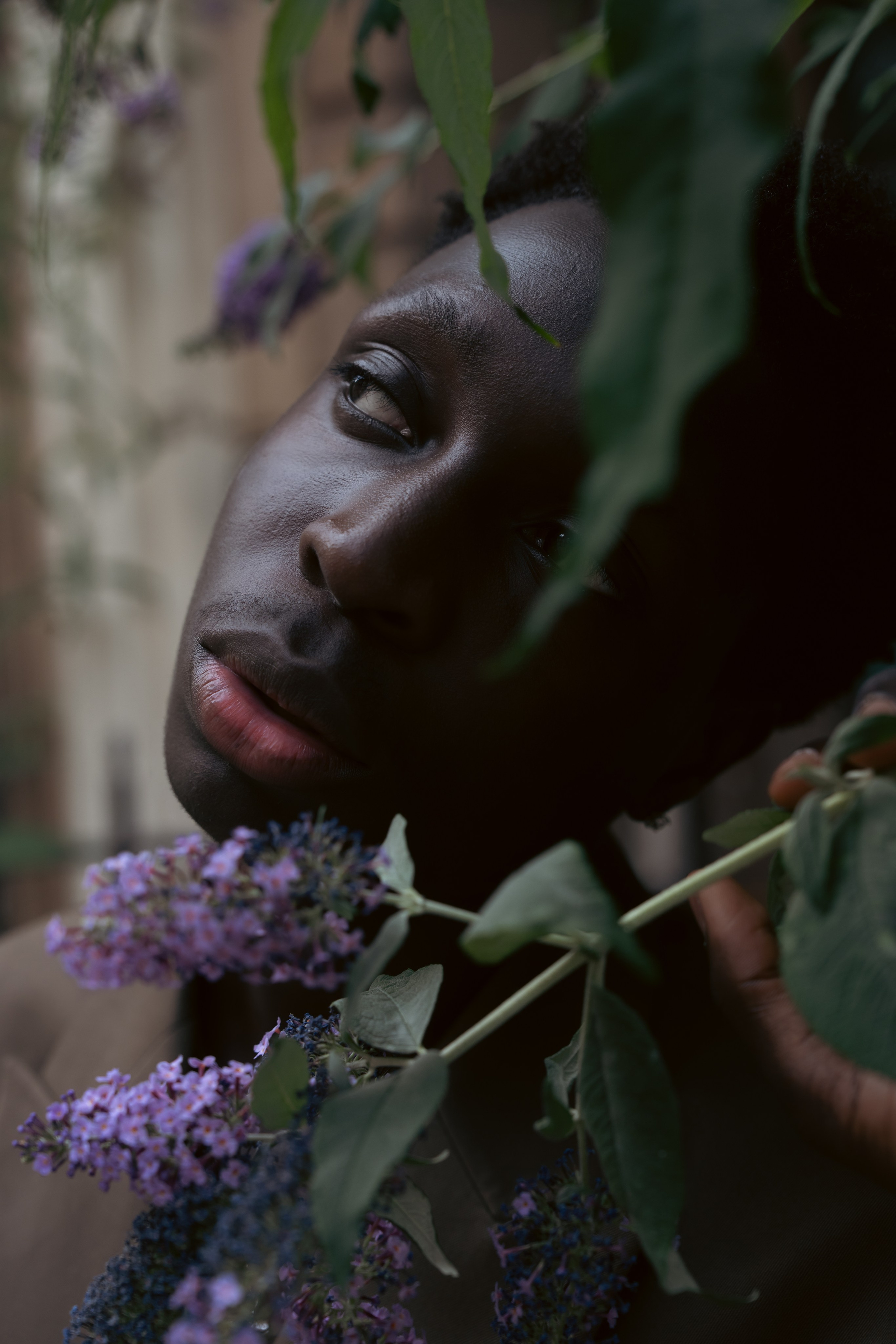 Editorial male portrait framed by flowers and foliage