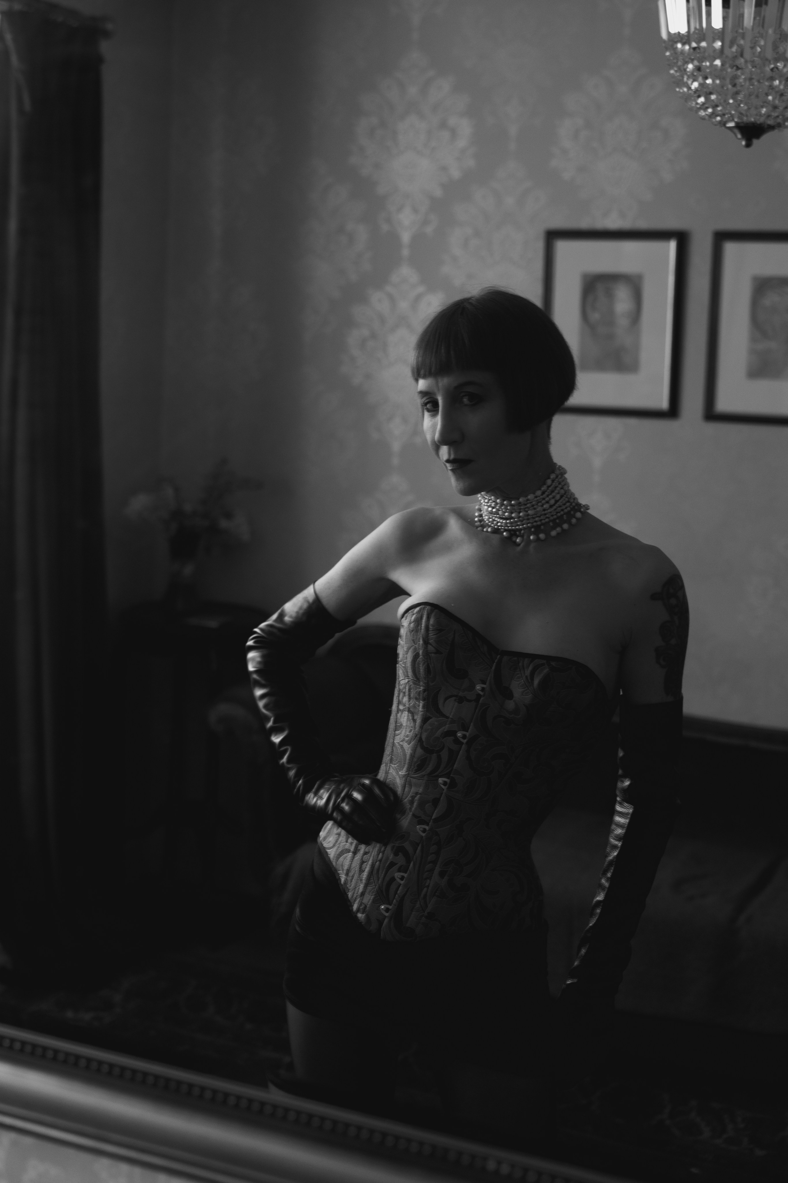 Creative black and white female portrait in a corset and long gloves. Vintage clothes show.