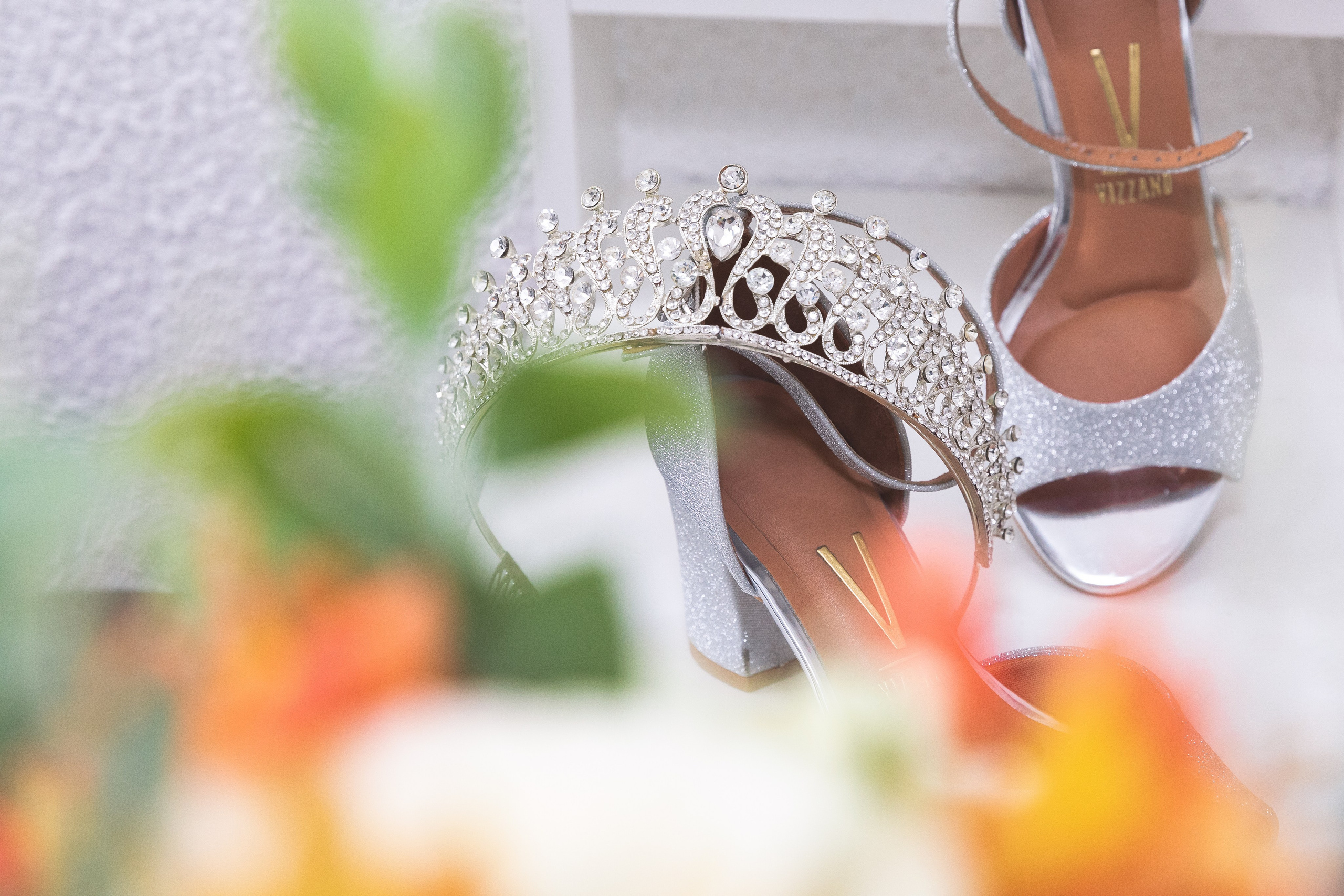 Sapatos da noiva com sua coroa a frente e buquê ao fundo, registro feito em seu making-of.