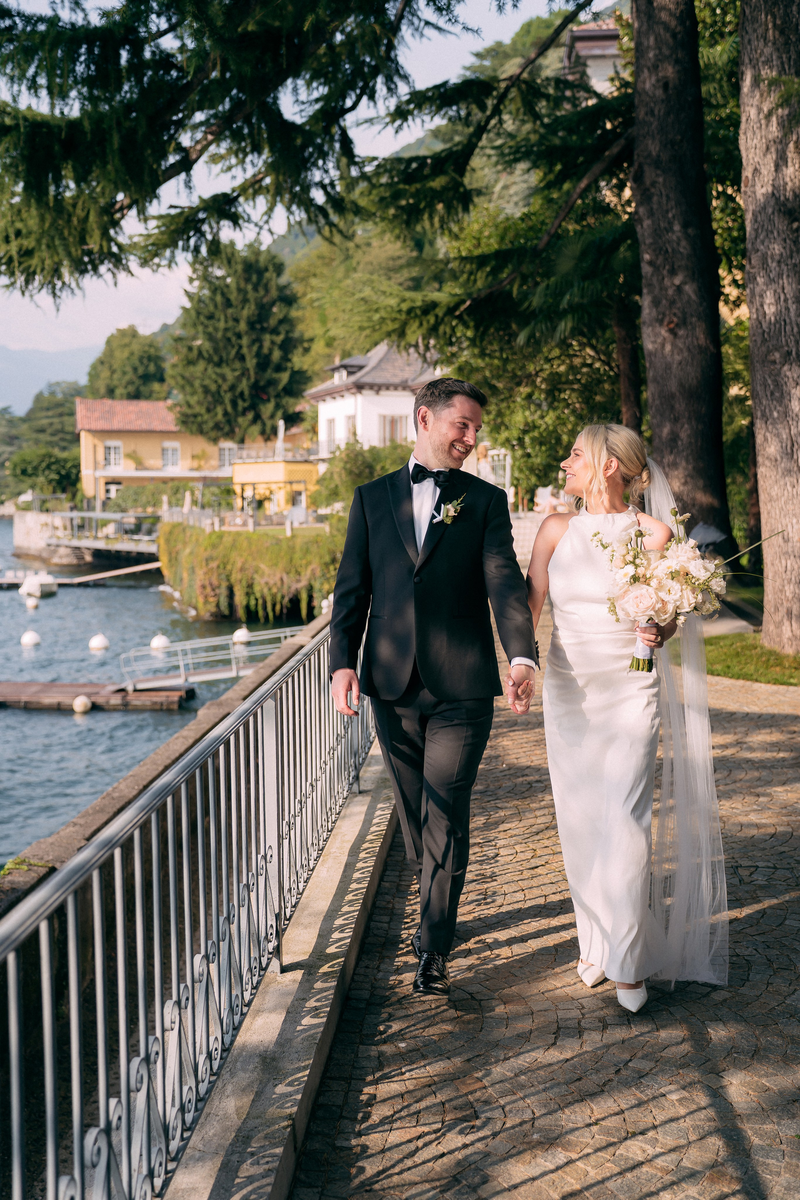 Couple walking along the dock at Villa Lario, Lake Como, Italy