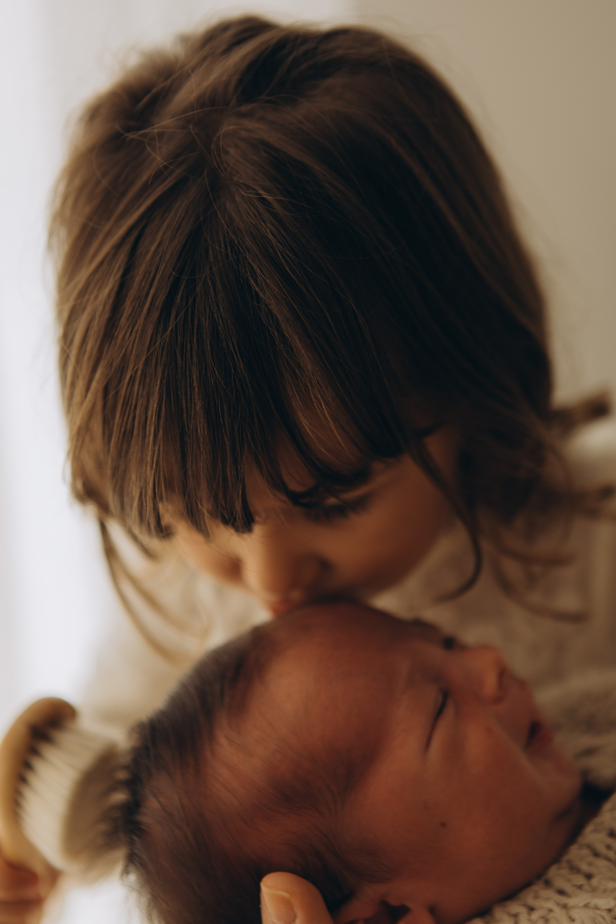 irmão beijando recém-nascido em ensaio de bebê em Sorocaba