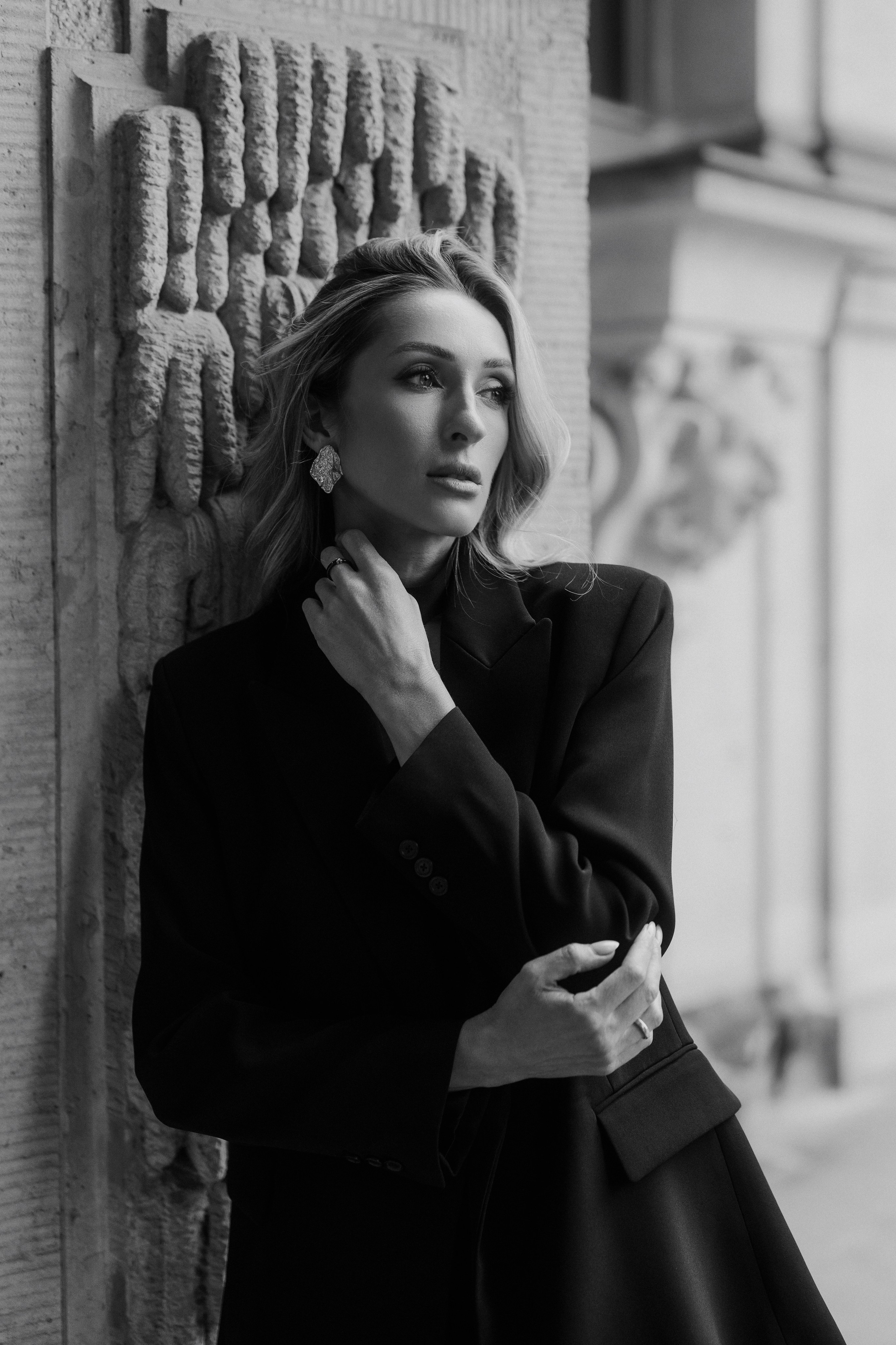 Fine art black and white portrait of an elegant woman in a black blazer beside historic architecture in Dresden, Germany. Editorial female portrait photography by a portrait photographer based near Leipzig and Wurzen. Художественный чёрно-белый портрет элегантной девушки в чёрном жакете на фоне исторической архитектуры Дрездена, Германия. Редакционная женская портретная фотография от фотографа из региона Лейпцига и Вурцена.