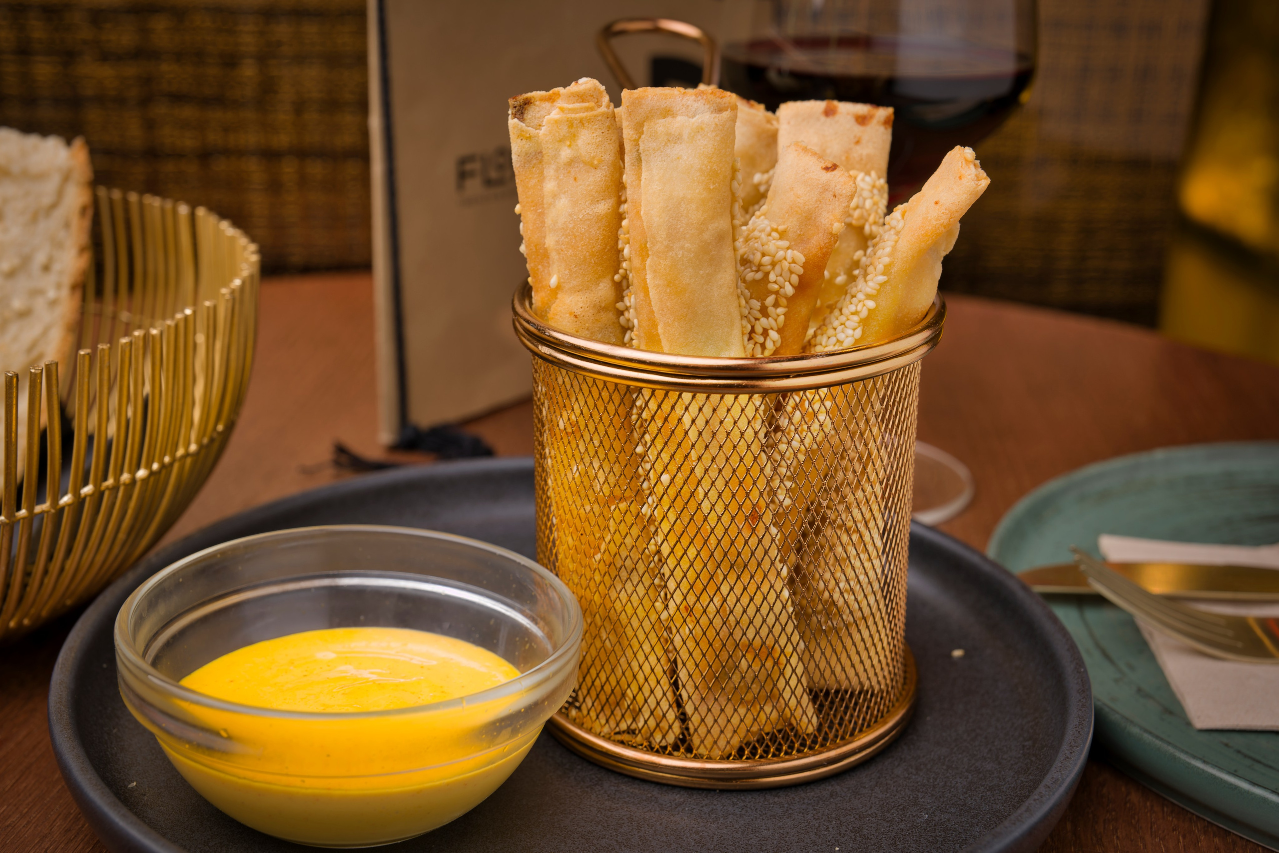 Fotografía gastronómica profesional de palitos de pan artesanales con salsa cremosa, ideal para restaurante gourmet o bar de tapas.