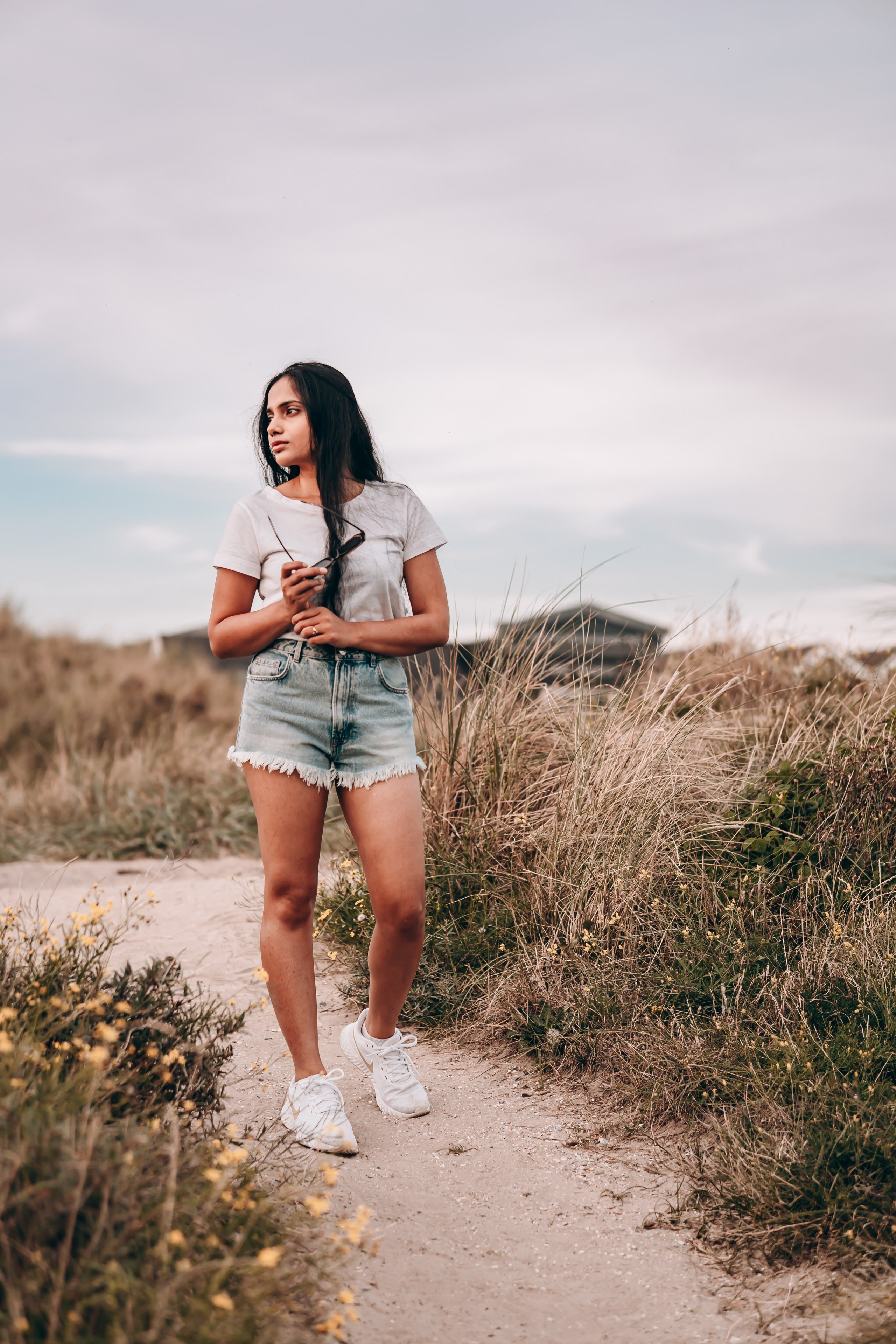 Woman walking along a narrow path close to the beach