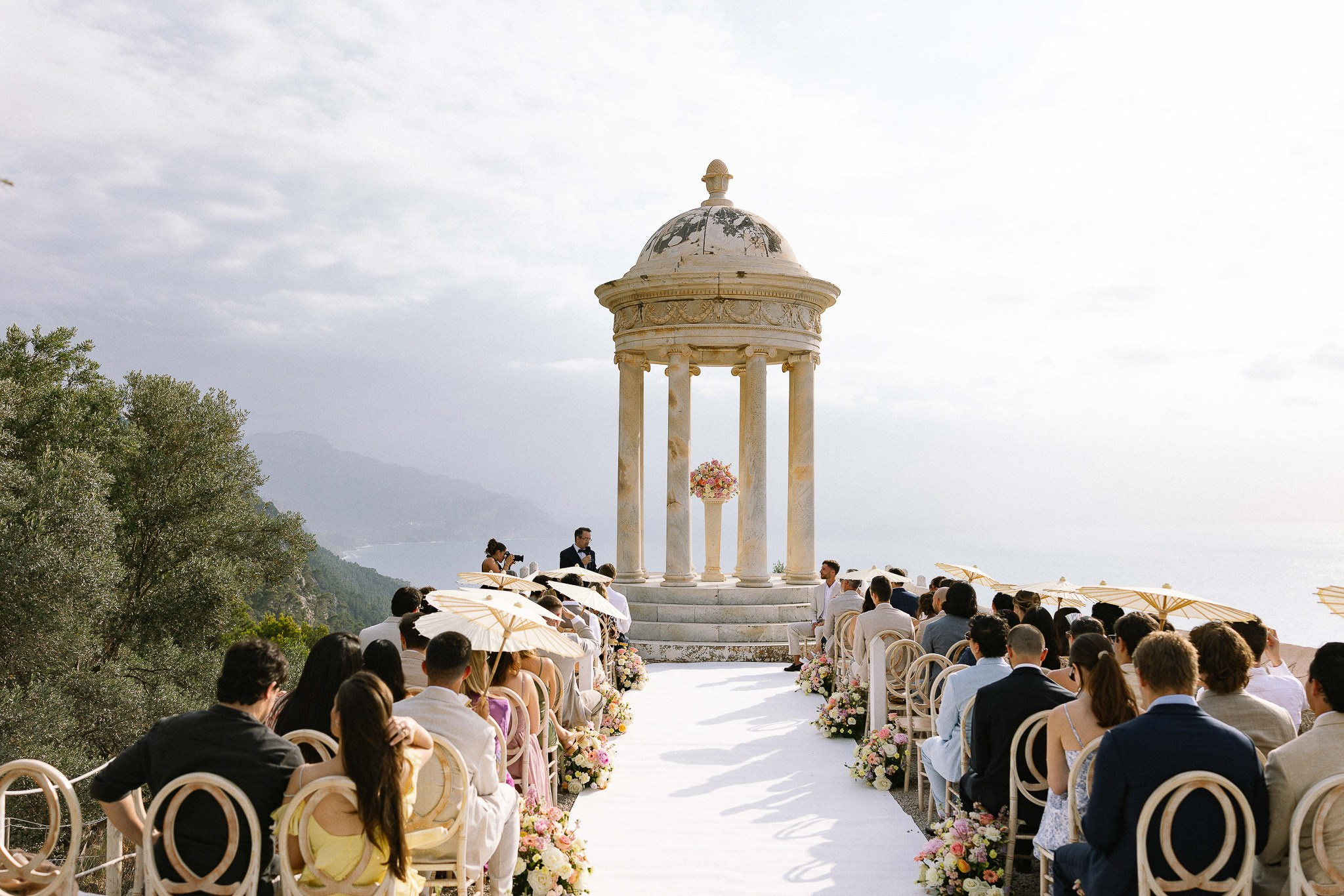 Guests seated under parasols at Son Marroig wedding ceremony