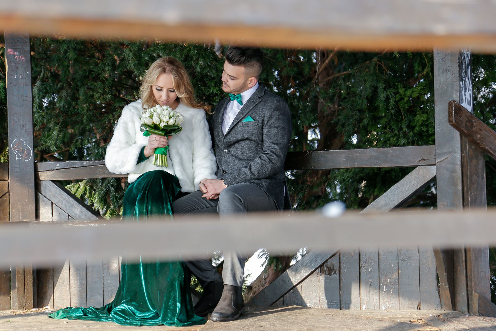 Smiling newlyweds sharing tender and loving glances, photographed close up inside the rustic park gazebo.