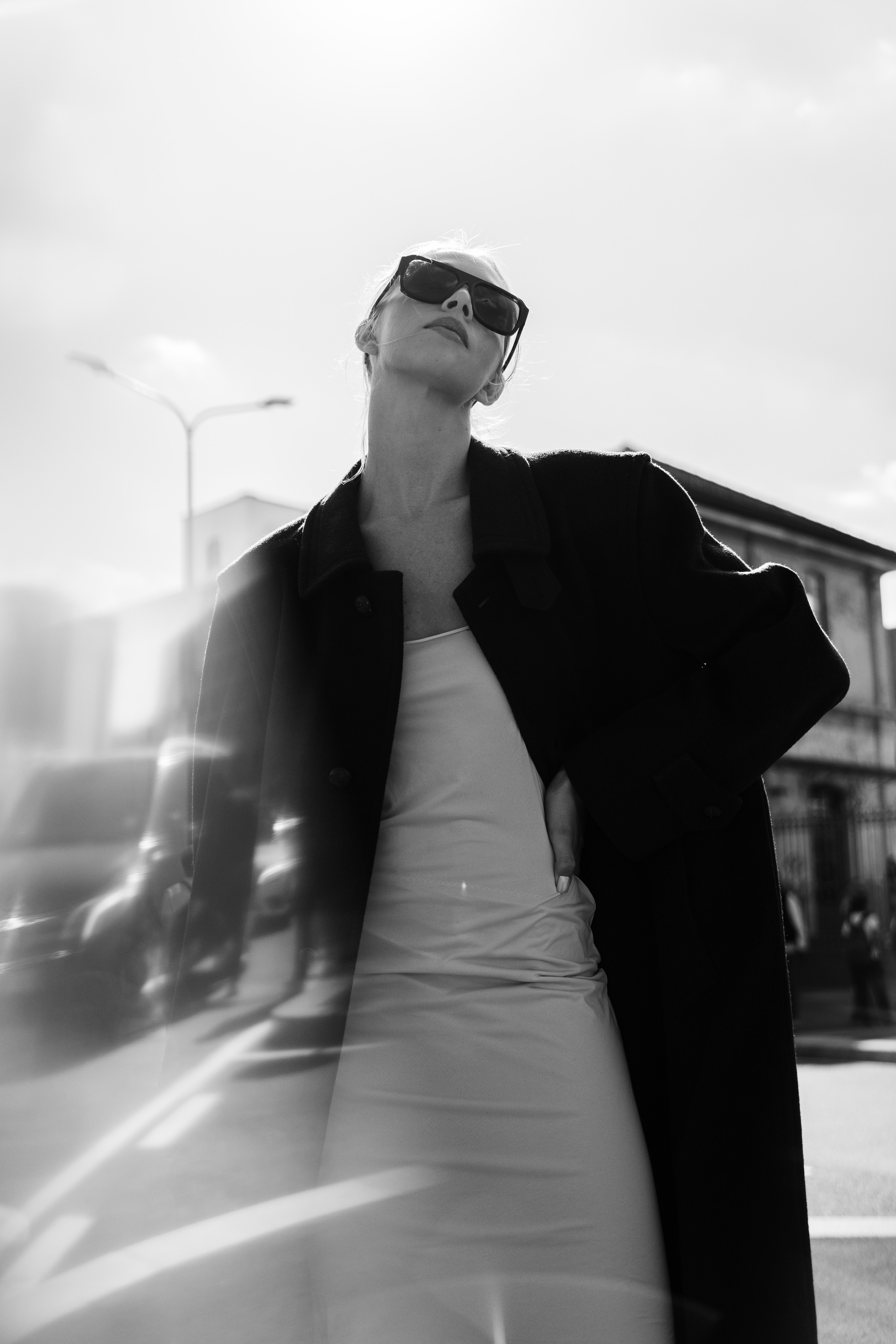 Stylish woman in a monochrome outfit with a blurred glass reflection effect in the foreground