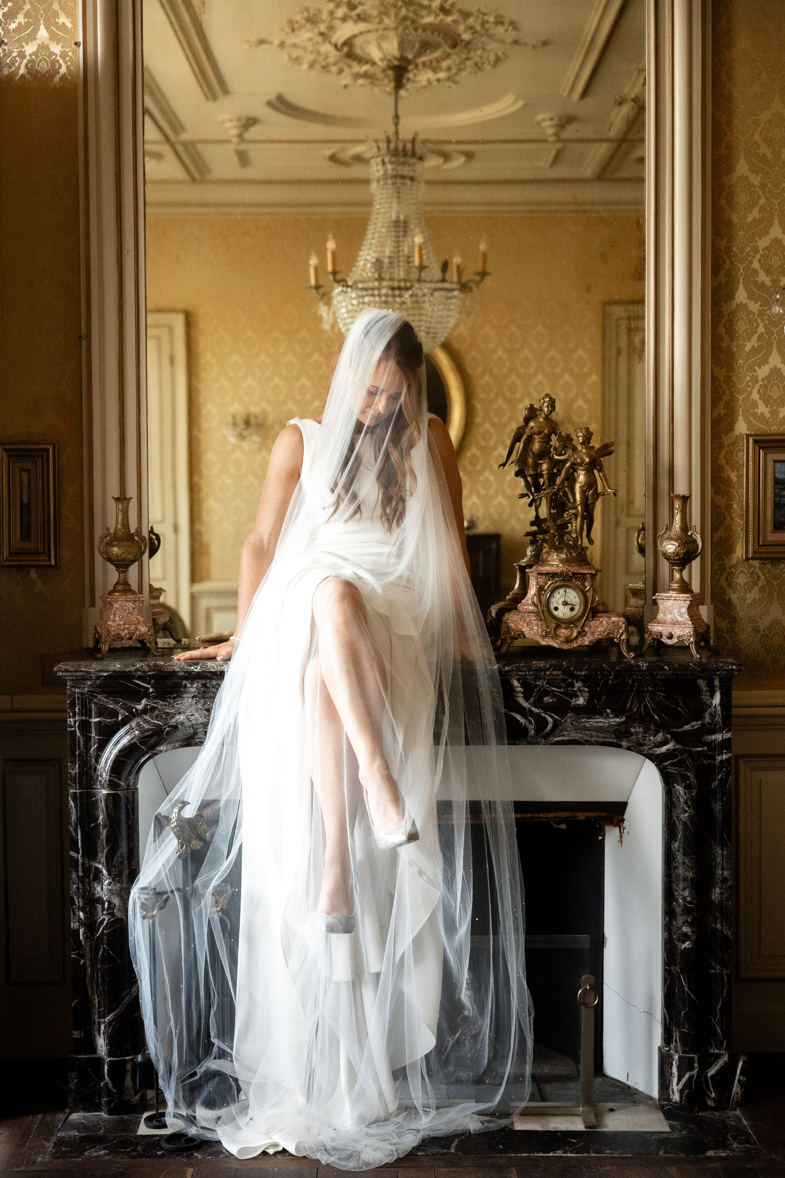 Bride with a long veil in a gilded salon at Château de la Borderie, Southwest France wedding