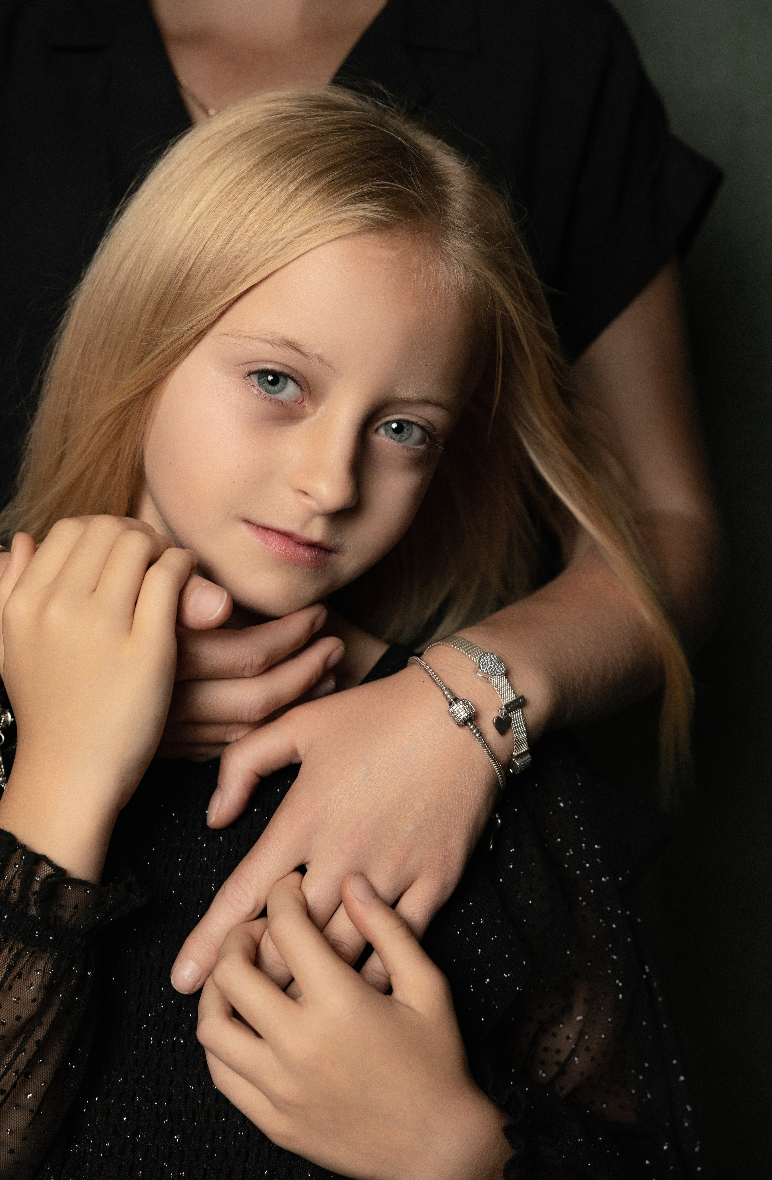 Stilvolles Kinderportrait mit Fine-Art-Lichtstimmung – Tochter hält die Hand ihrer Mutter beim Fotoshooting in Salzburg