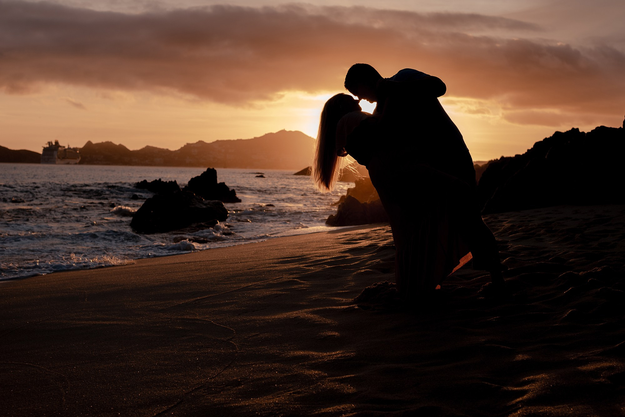 Family silhouette during golden hour sunset at Playa Monumentos Cabo San Lucas Baja California Sur Mexico