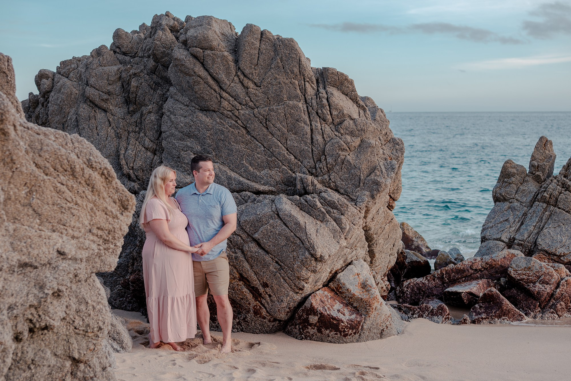 Candid moment of family with baby and grandmother walking along Playa Monumentos Cabo San Lucas at sunset