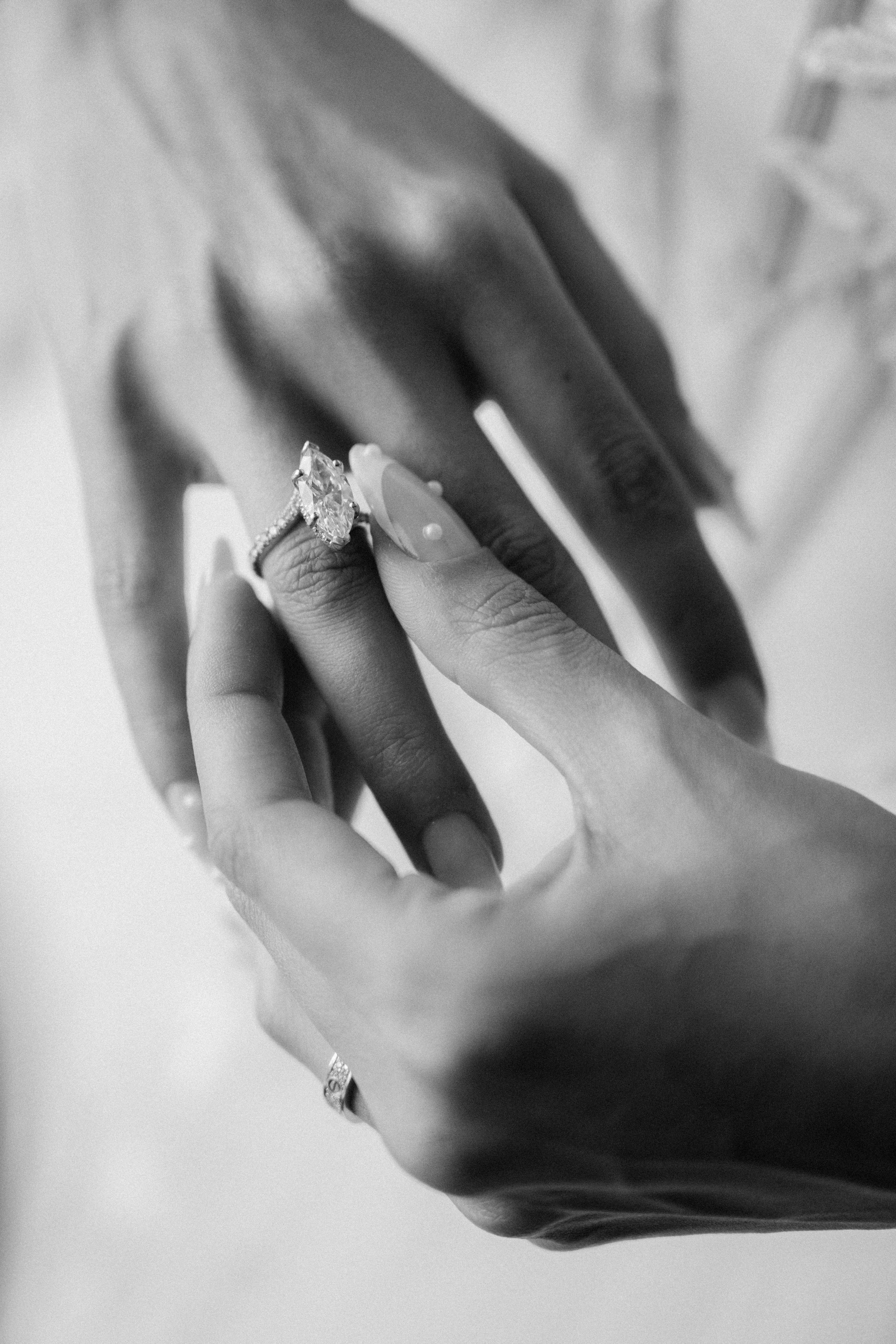Black and white close up of hands with wedding rings