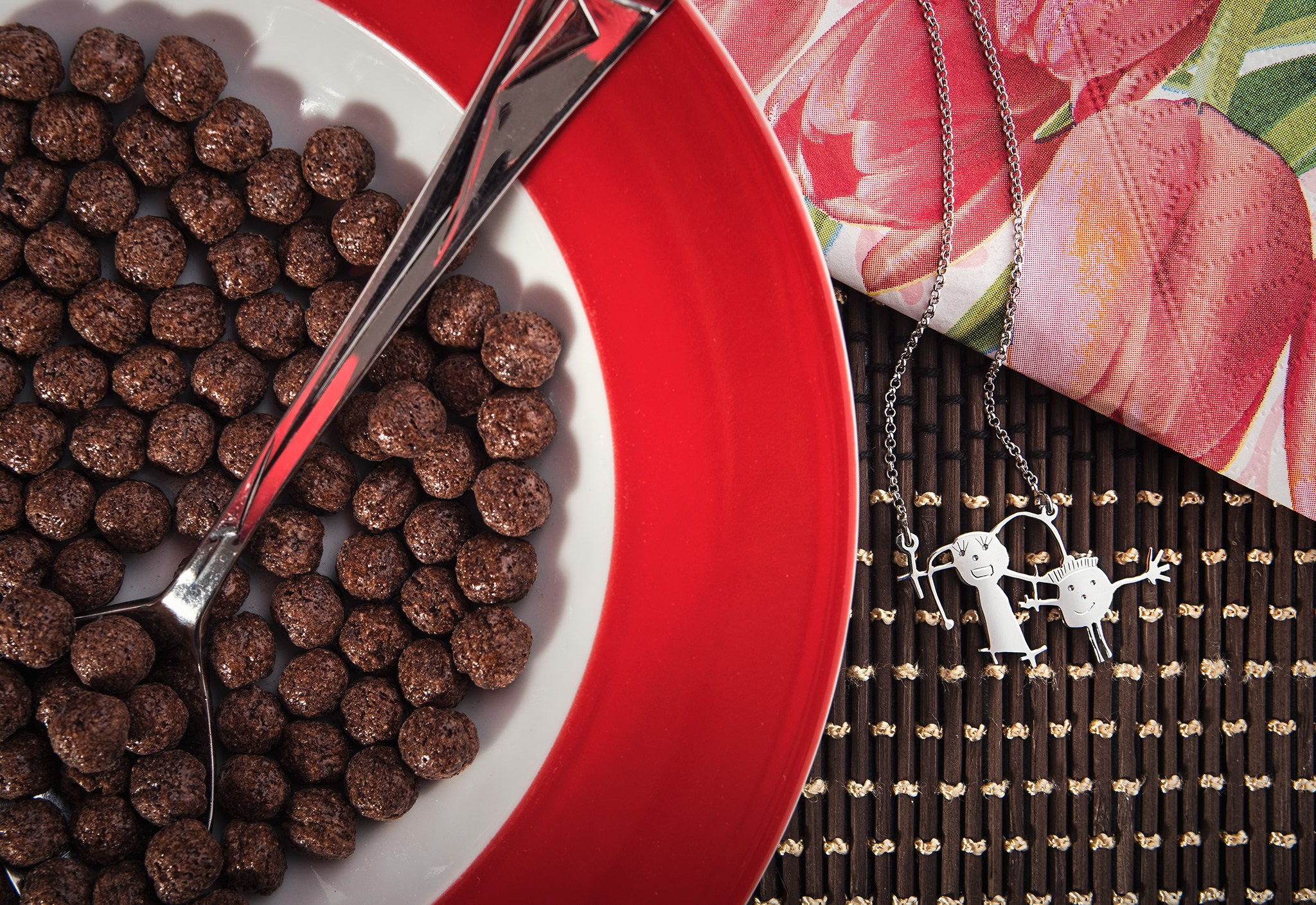 Ogrlica na stolu pored tanjira sa dečijim kuglicama.