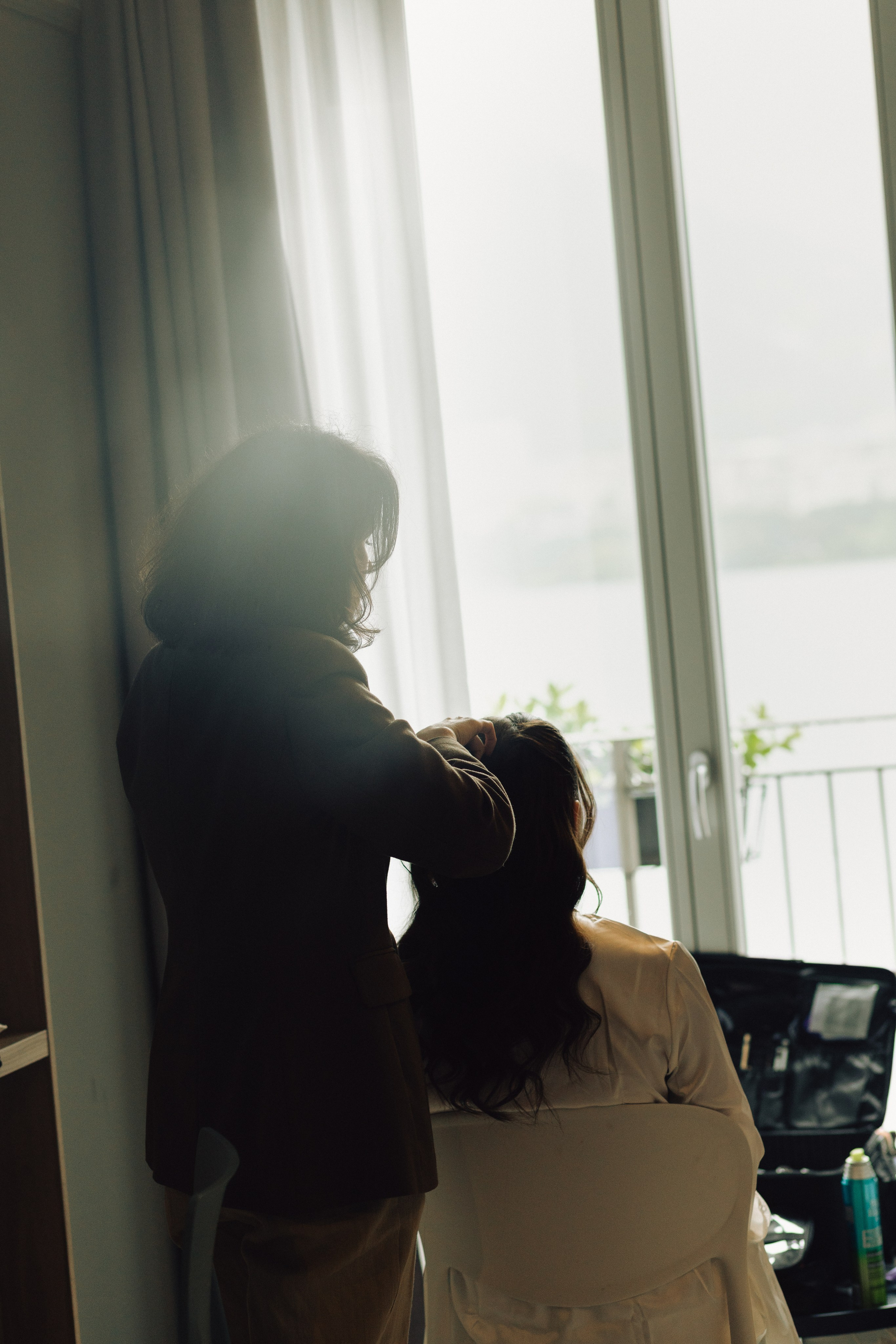 Bride sitting by the window during preparations for her destination wedding in Italy