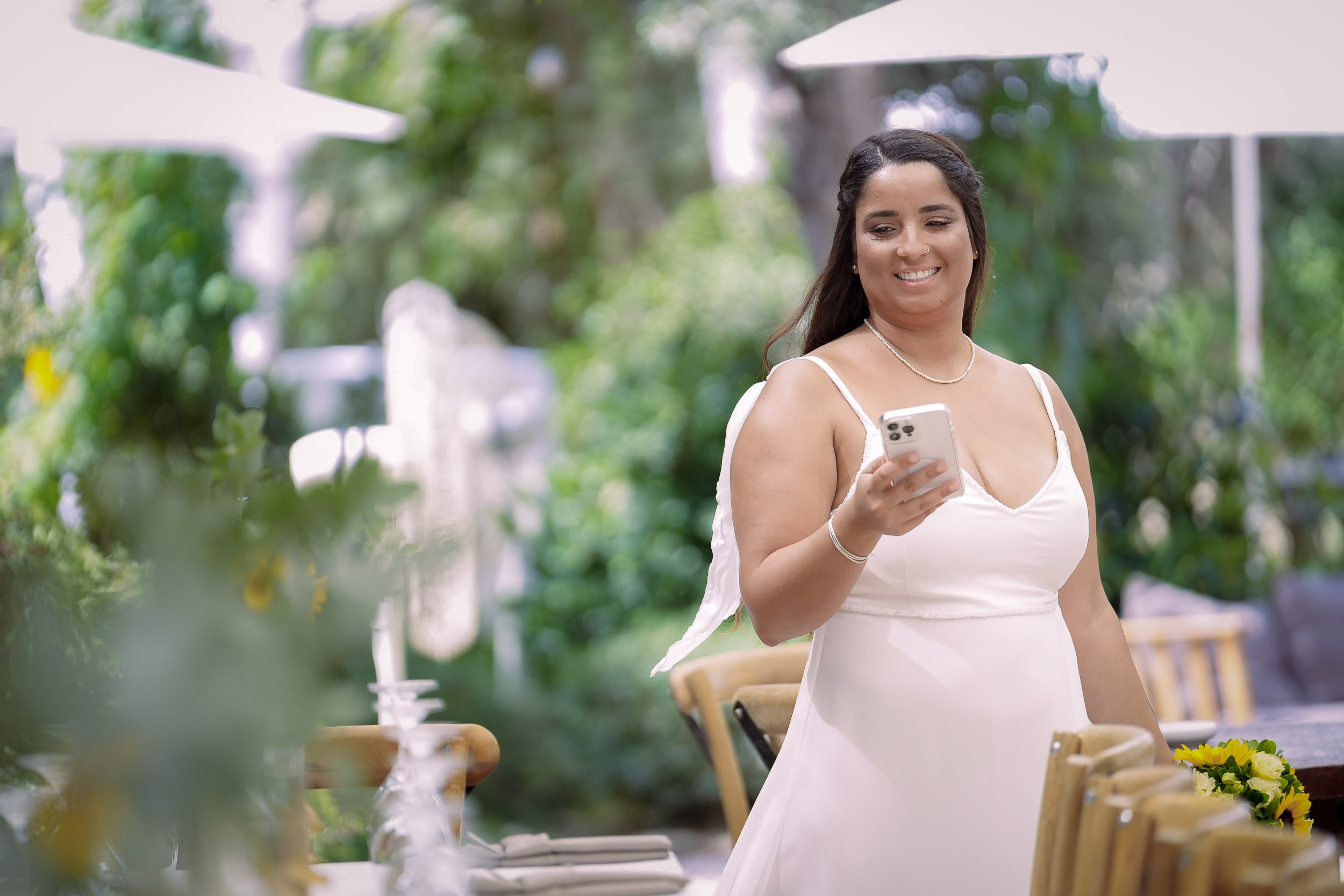 Talia holds a sunflower bouquet and her phone during the morning preparations