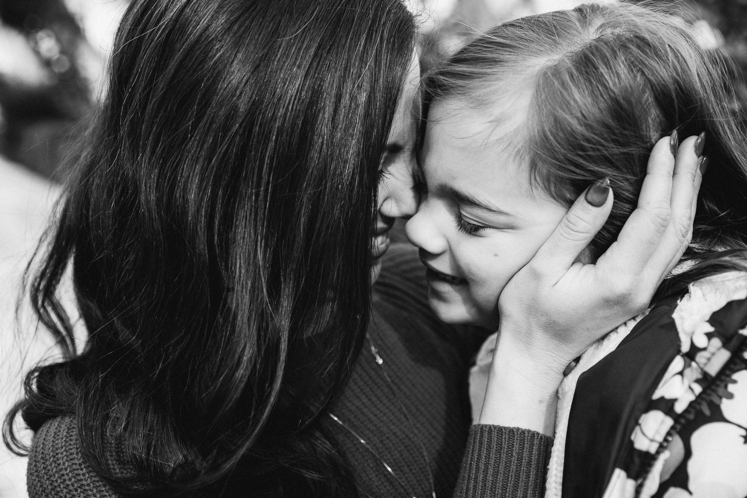 Семейная фотосессия в Валенсии, Испания, где мама нежно держит лицо своего ребёнка в интимном чёрно-белом портрете, передавая глубокую эмоциональную связь и нежность — идеально для семейных фотосессий в Валенсии и по всей Испании.