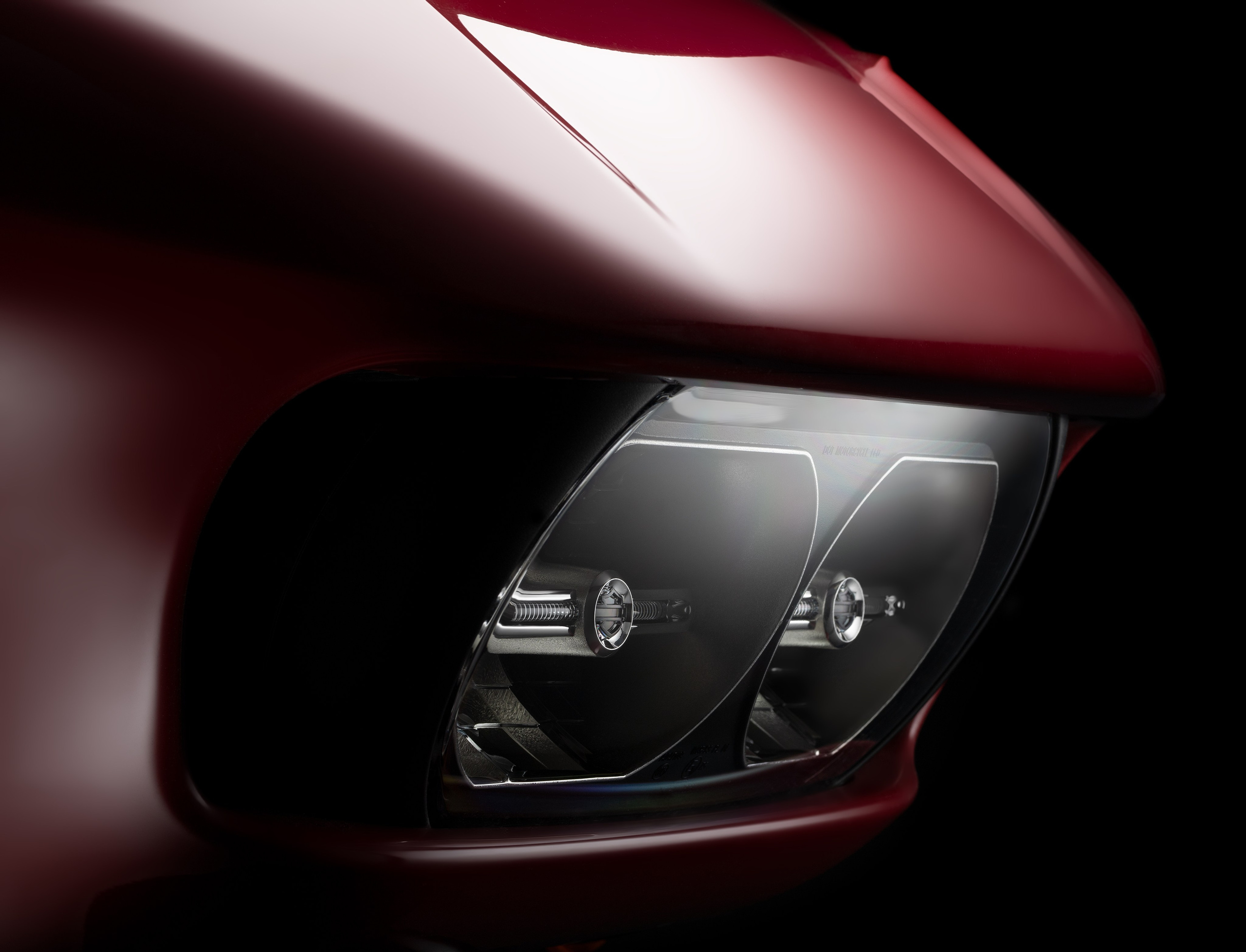 Fotografia reklamowa detalu motocykla – reflektor i karoseria w kolorze ciemnej czerwieni. Focusiv Studio – fotografia motoryzacyjna i produktowa dla marek premium, Gorzów Wielkopolski, Poznań, Szczecin, Wrocław, Zielona Góra.