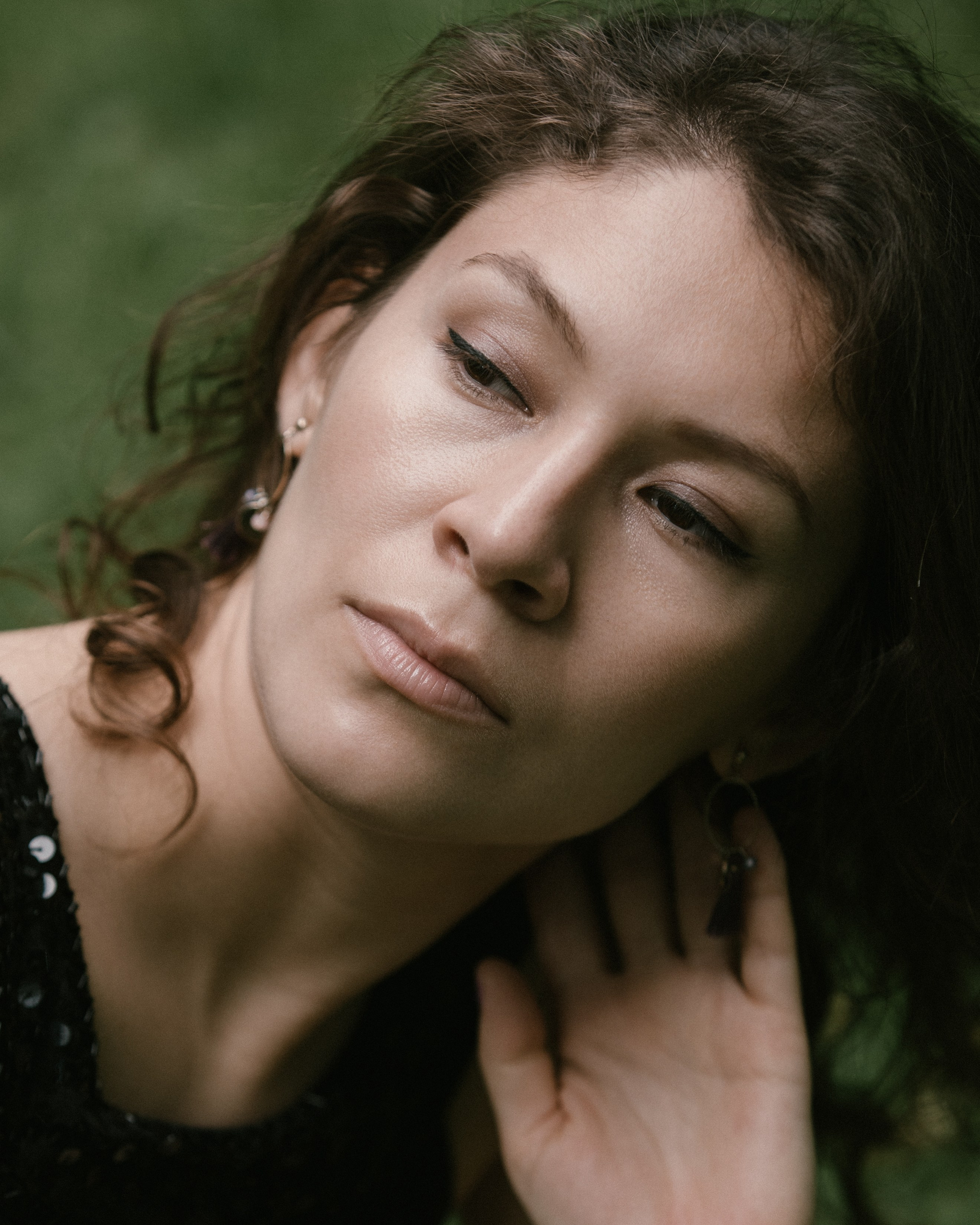 Sanftes Porträt, lockiges Haar und Hand am Hals