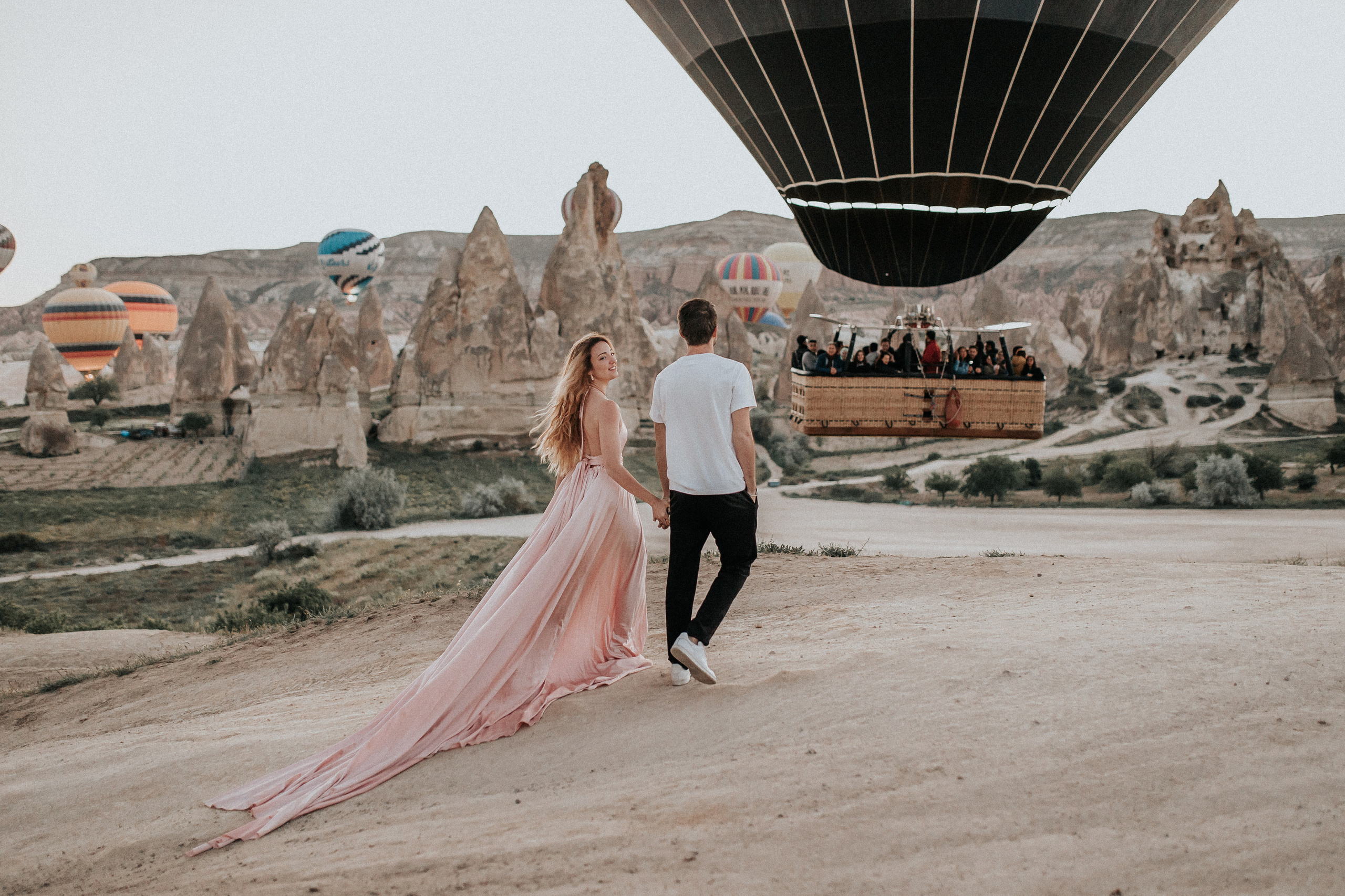 Paarfotografie beim Sonnenaufgang mit Heissluftballons im Hintergrund. Familien- & Hochzeitsfotografin Schweiz. Valeria Diaz in Zürich und Umgebung