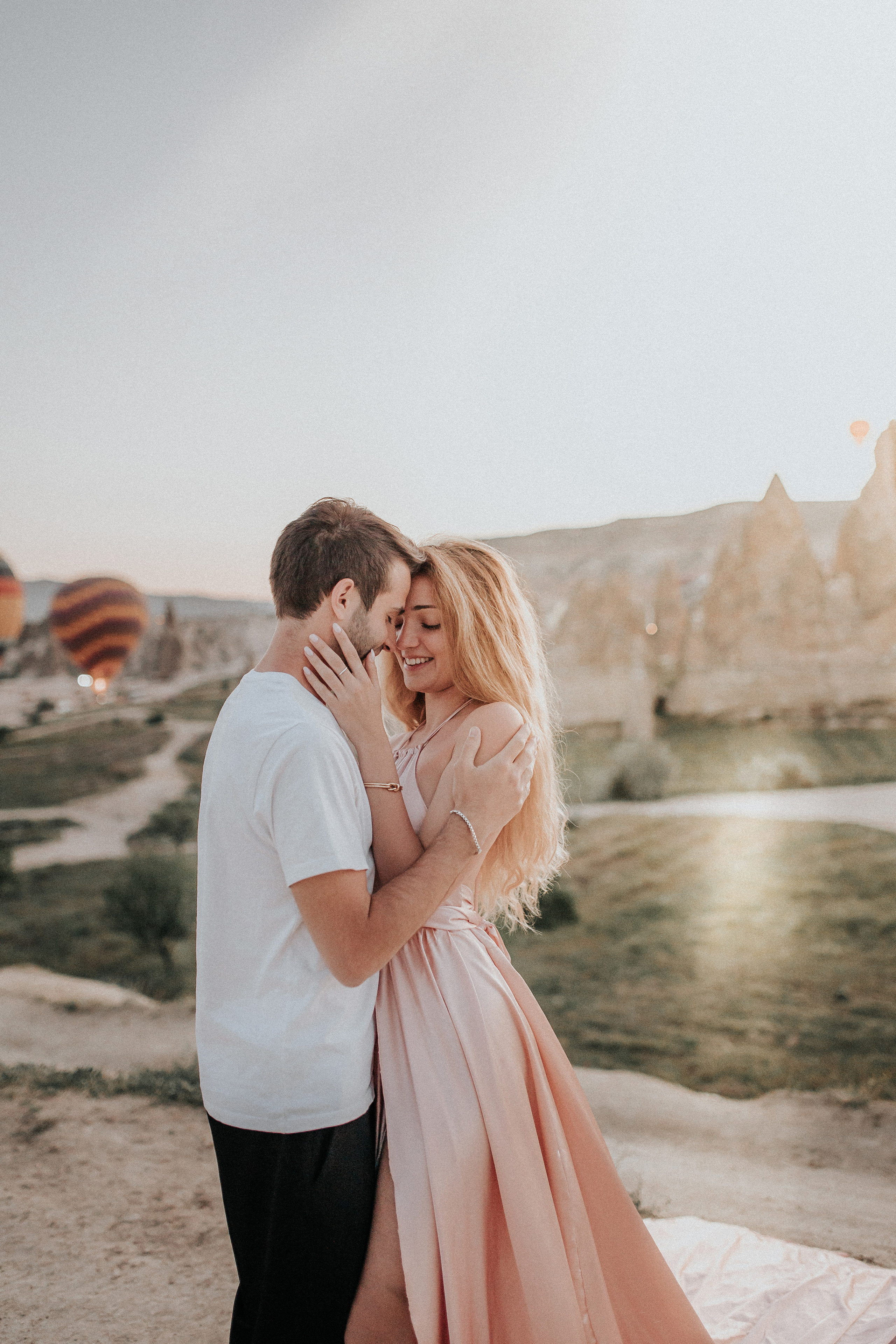 Paarfotografie beim Sonnenaufgang mit Heissluftballons im Hintergrund. Familien- & Hochzeitsfotografin Schweiz. Valeria Diaz in Zürich und Umgebung