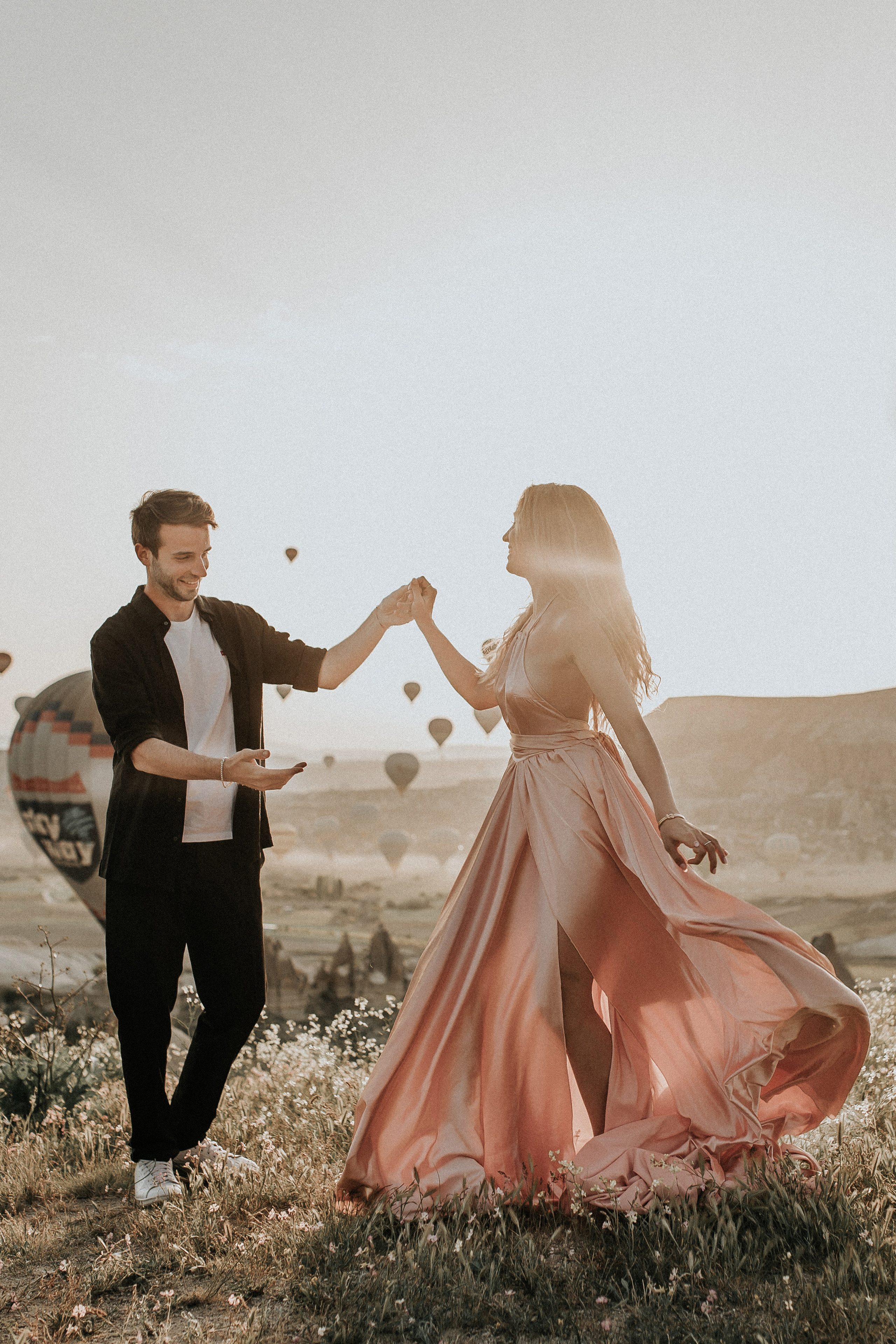 Paarfotografie beim Sonnenaufgang mit Heissluftballons im Hintergrund. Familien- & Hochzeitsfotografin Schweiz. Valeria Diaz in Zürich und Umgebung