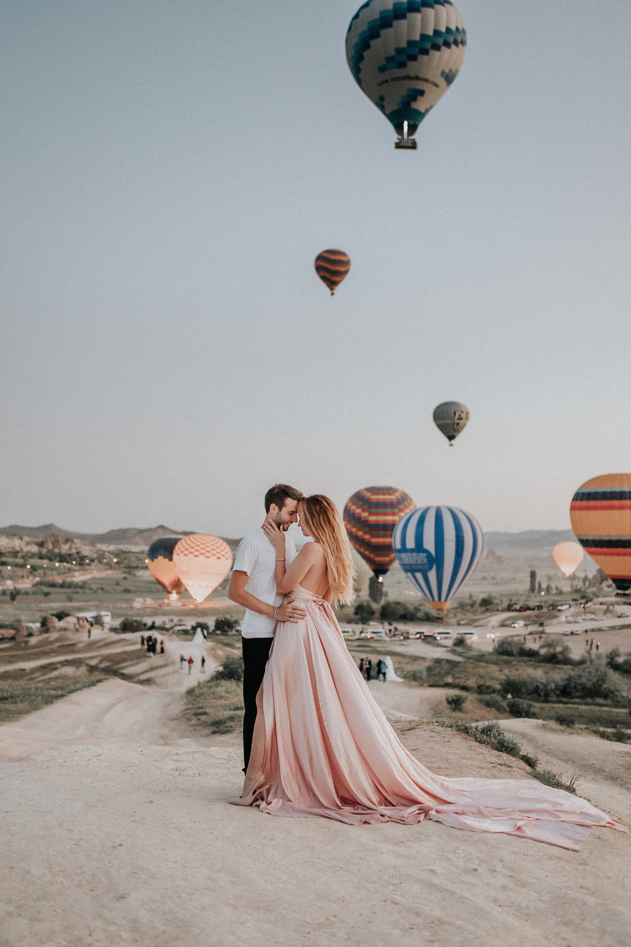 Paarfotografie beim Sonnenaufgang mit Heissluftballons im Hintergrund. Familien- & Hochzeitsfotografin Schweiz. Valeria Diaz in Zürich und Umgebung