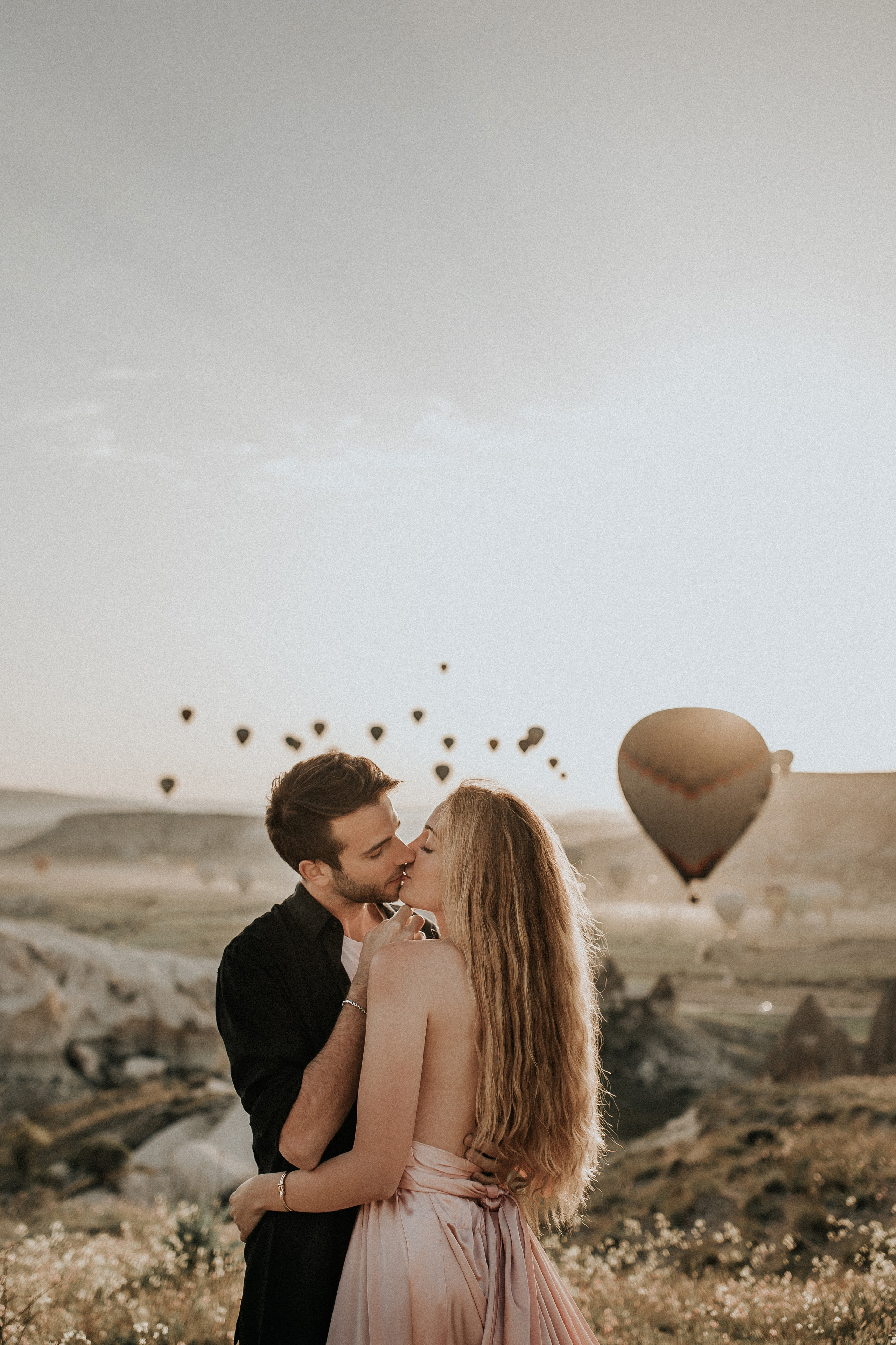 Paarfotografie beim Sonnenaufgang mit Heissluftballons im Hintergrund. Familien- & Hochzeitsfotografin Schweiz. Valeria Diaz in Zürich und Umgebung