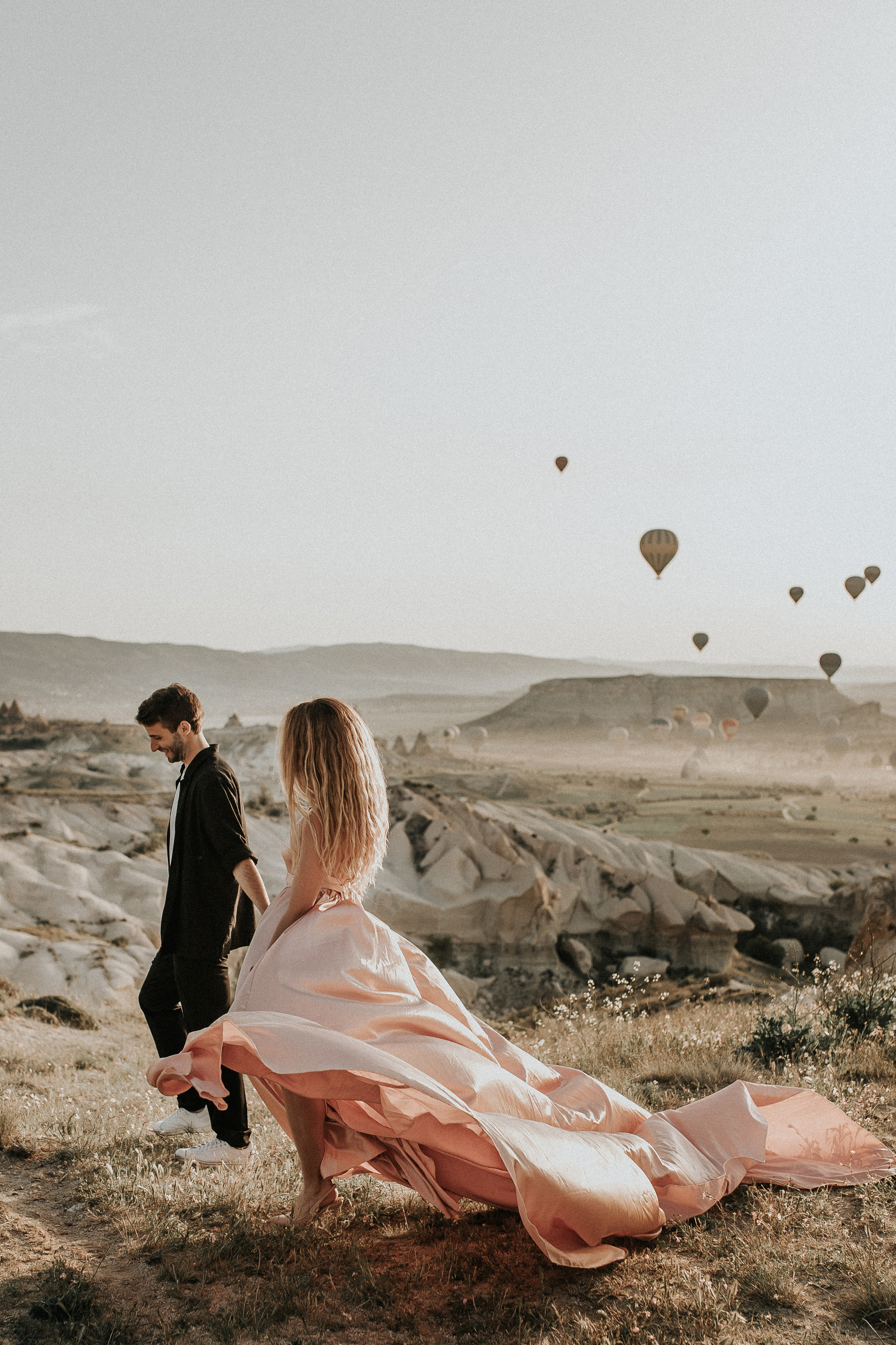 Paarfotografie beim Sonnenaufgang mit Heissluftballons im Hintergrund. Familien- & Hochzeitsfotografin Schweiz. Valeria Diaz in Zürich und Umgebung